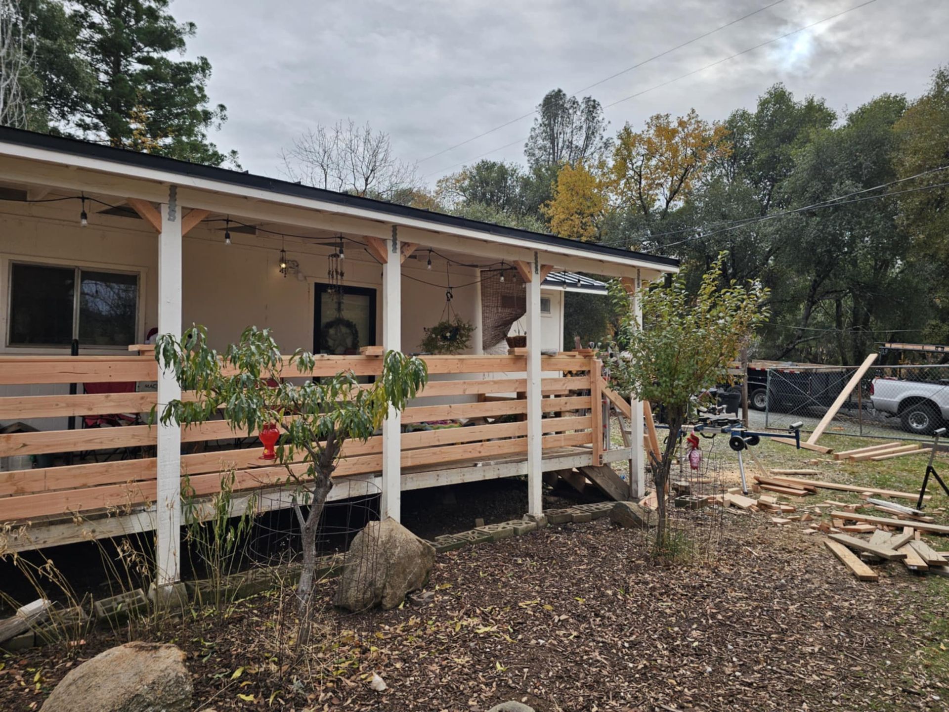 A house with a porch and a wooden railing is being built.