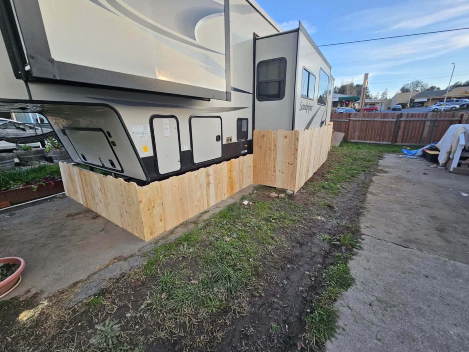 A rv is parked next to a wooden fence.