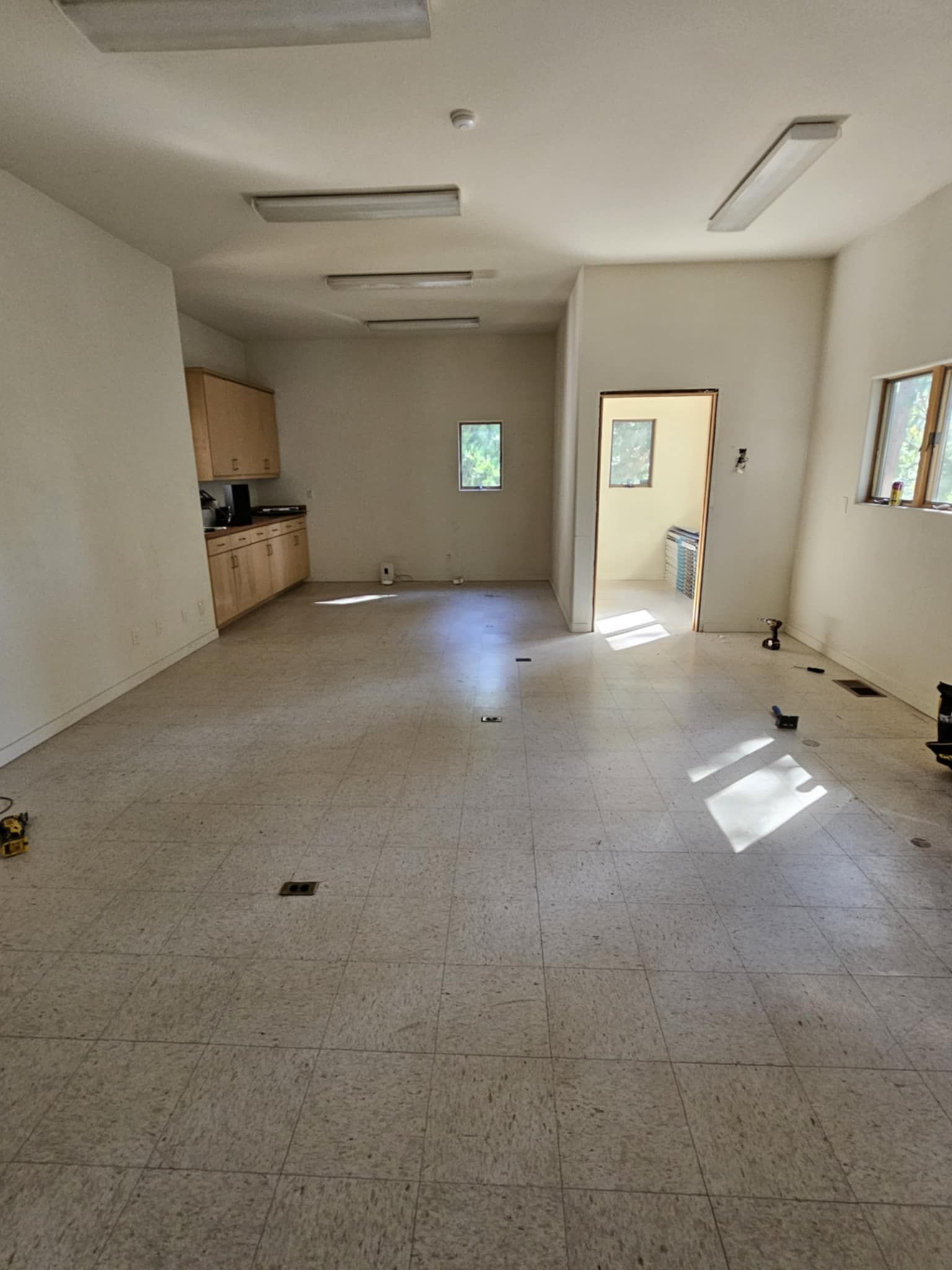 An empty room with a tiled floor and white walls