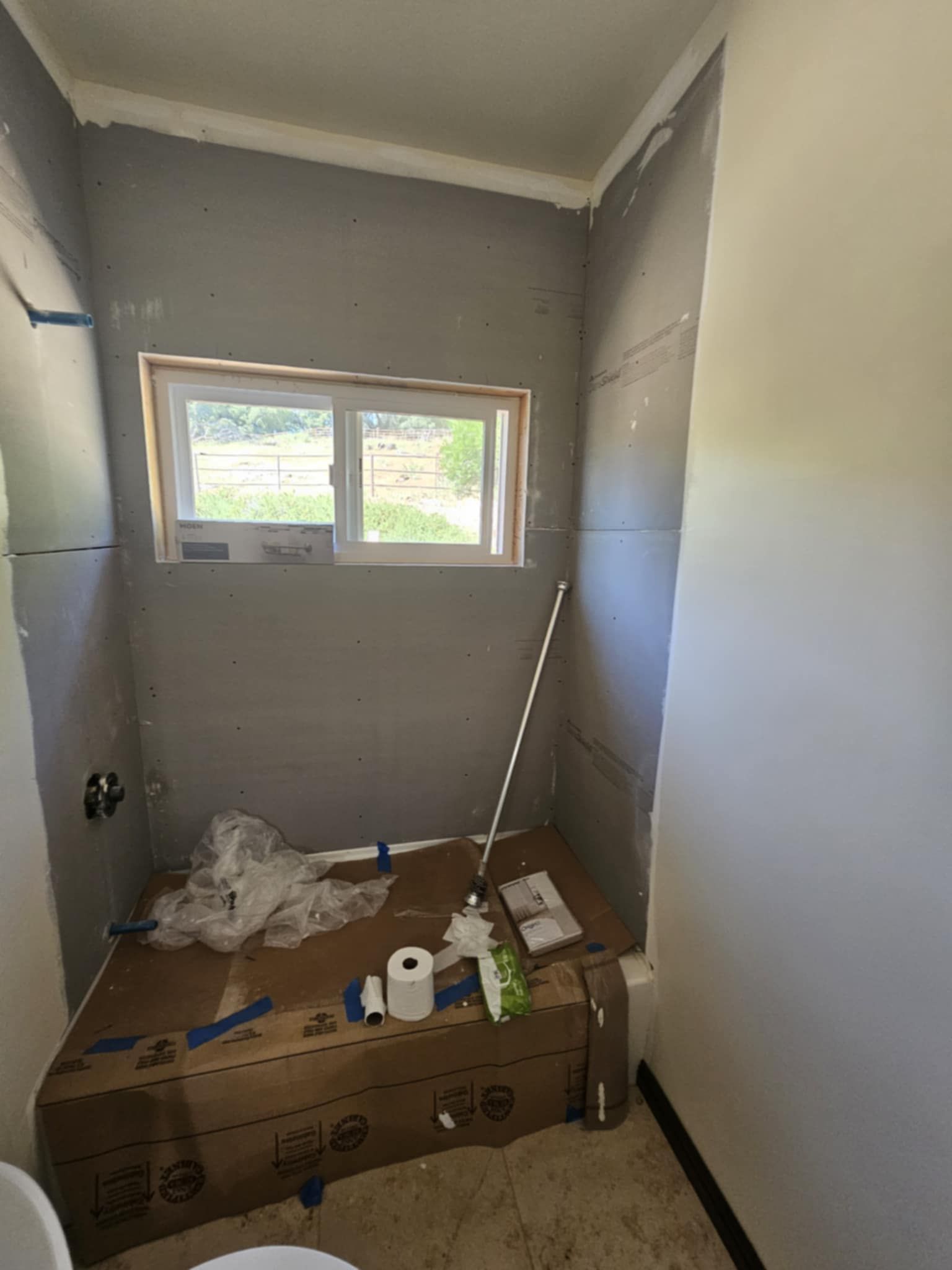A bathroom with a toilet and a box on the floor