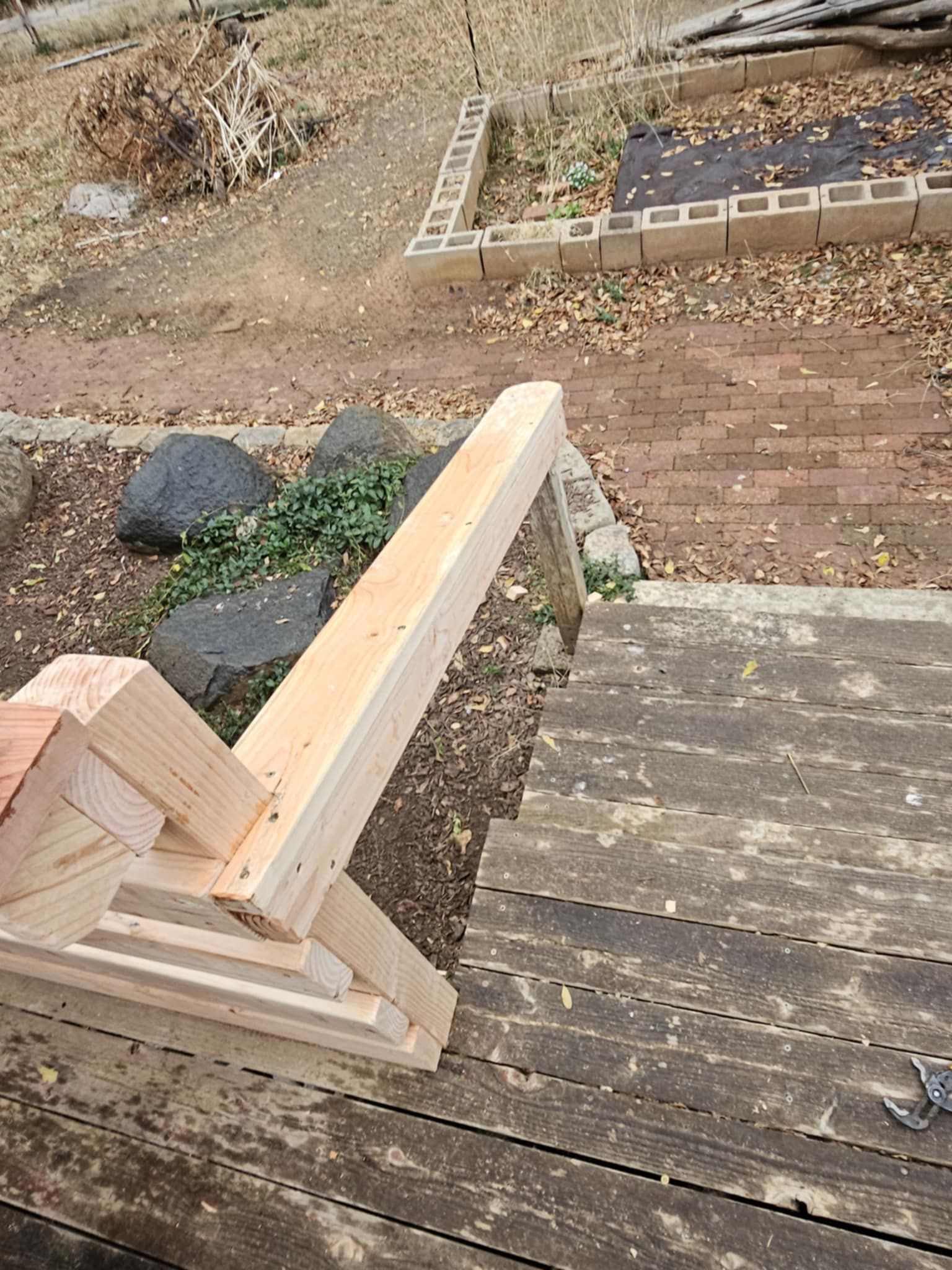 A wooden bench is sitting on top of a wooden deck.