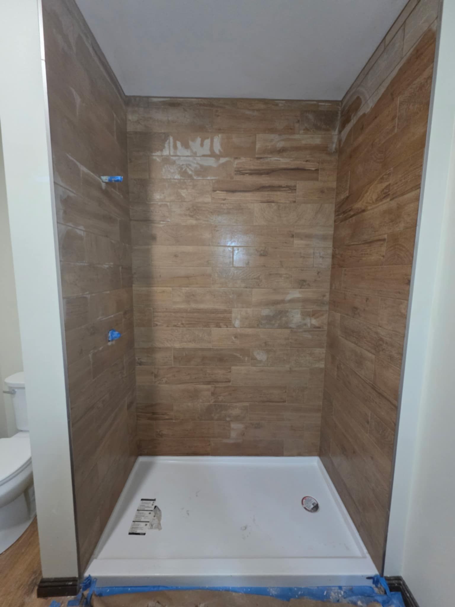 A bathroom with a shower stall and a toilet.