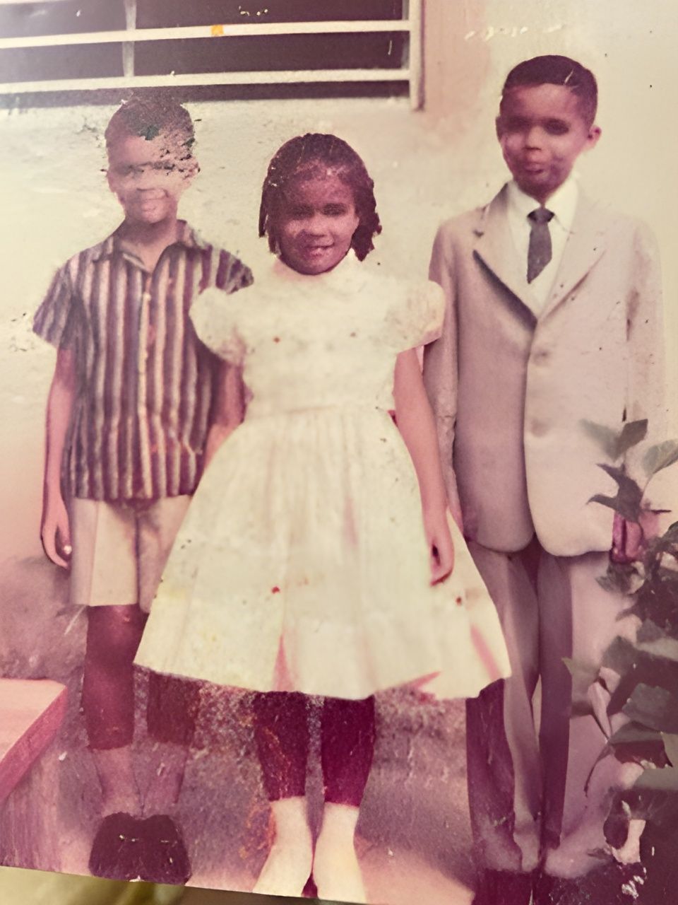 Two boys and a girl are posing for a picture