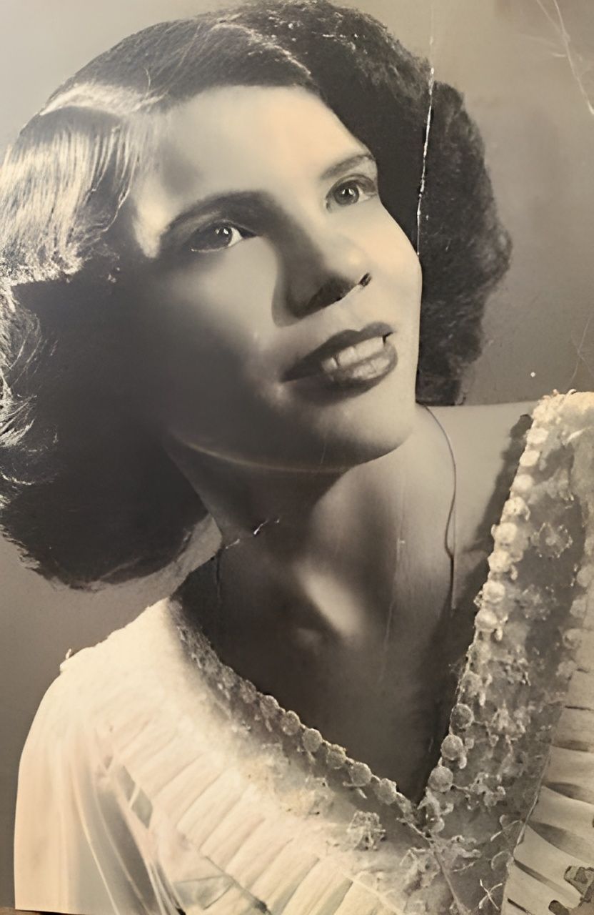 A black and white photo of a woman in a white dress.