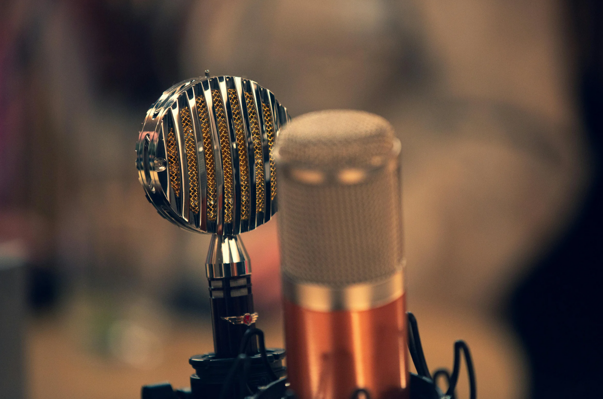 Two microphones are sitting next to each other on a table.