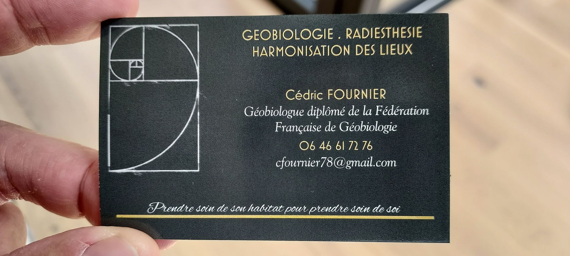 une personne tient une carte de visite pour cédric fournier