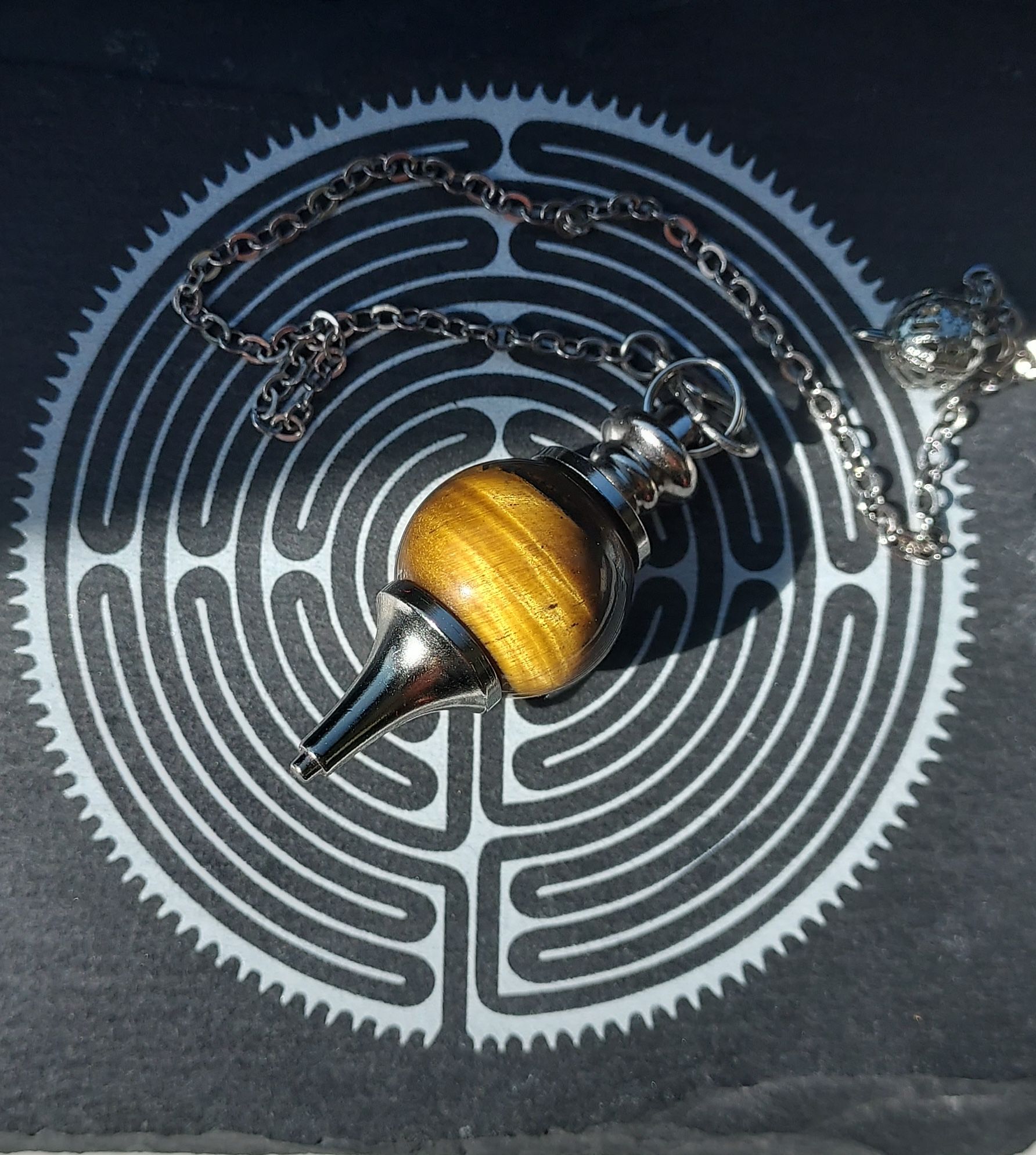un pendule est posé sur un labyrinthe avec une chaîne