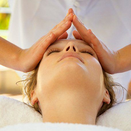 une femme reçoit un massage du visage dans un spa .