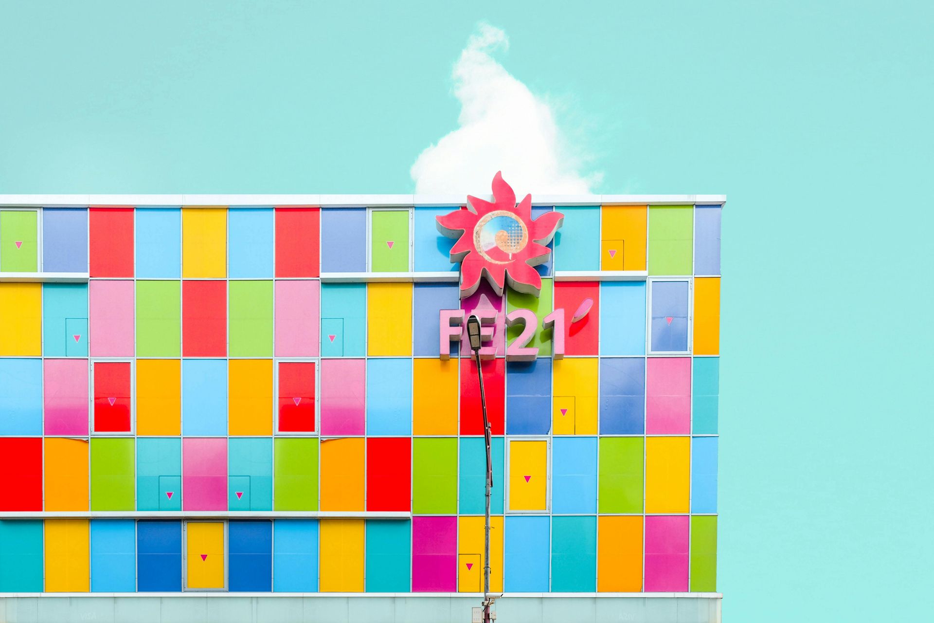 A colorful building with a sign on the side and a blue sky in the background.