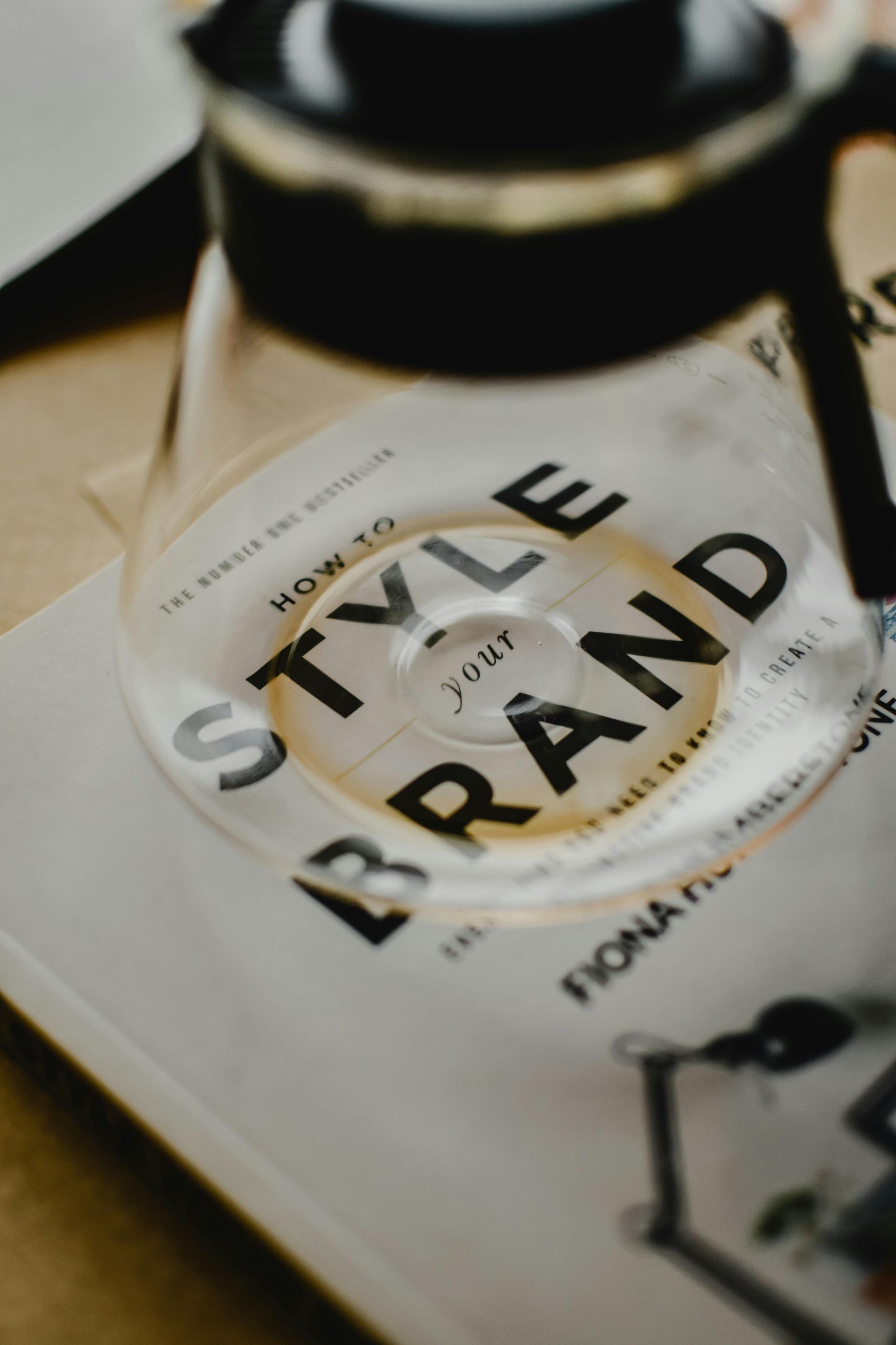 A glass sitting on top of a book titled how to style brand