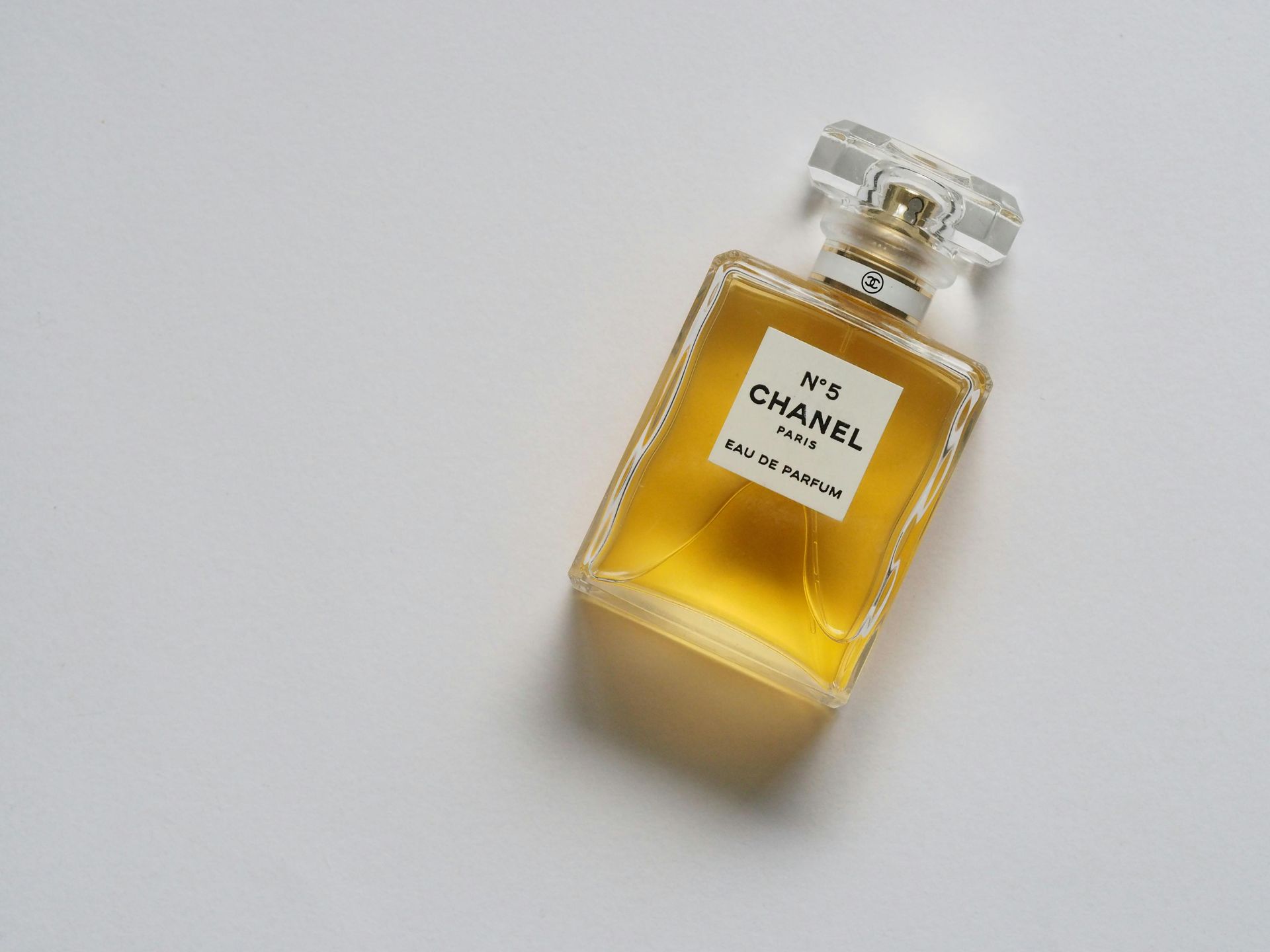A bottle of chanel no 5 perfume is sitting on a white surface.