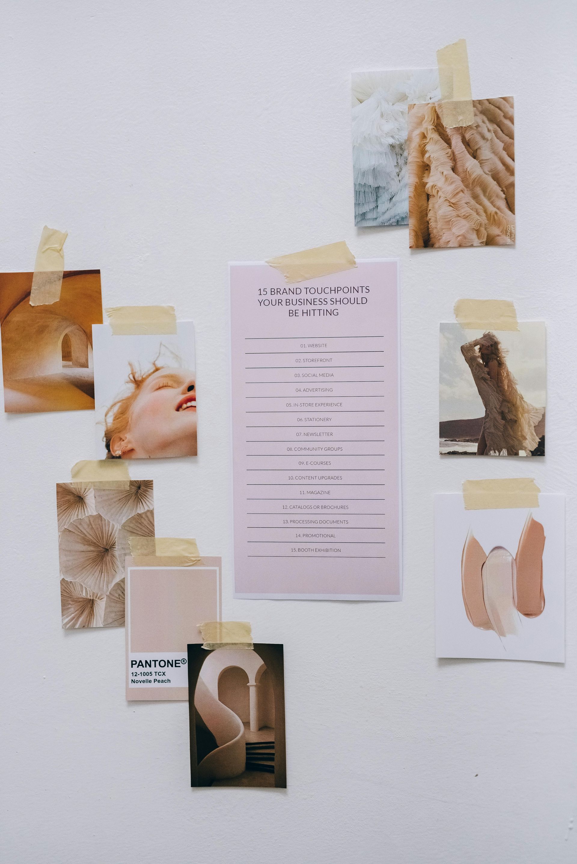 A bunch of pictures are taped to a white wall.
