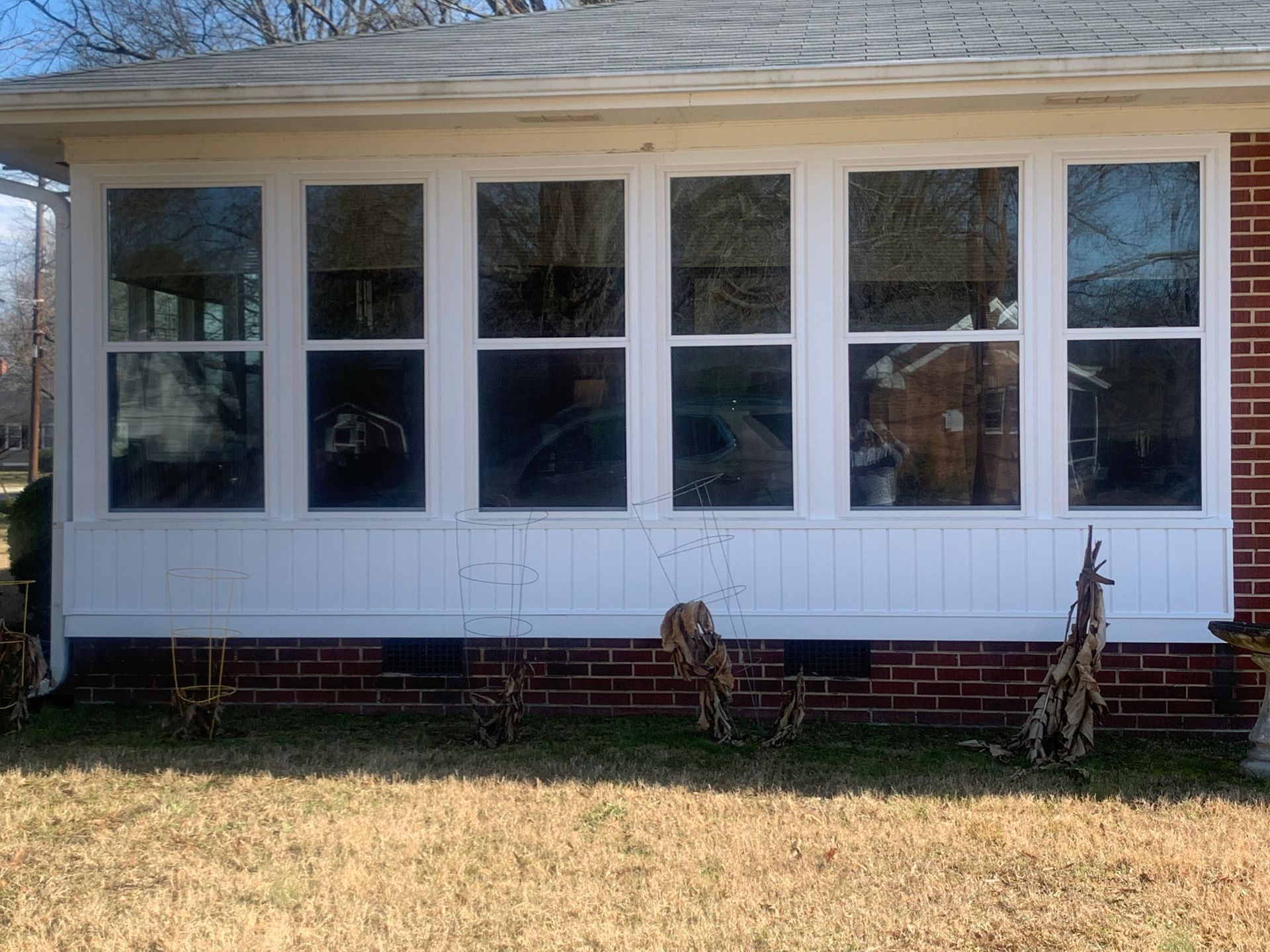 A white house with a lot of windows and a brick wall.