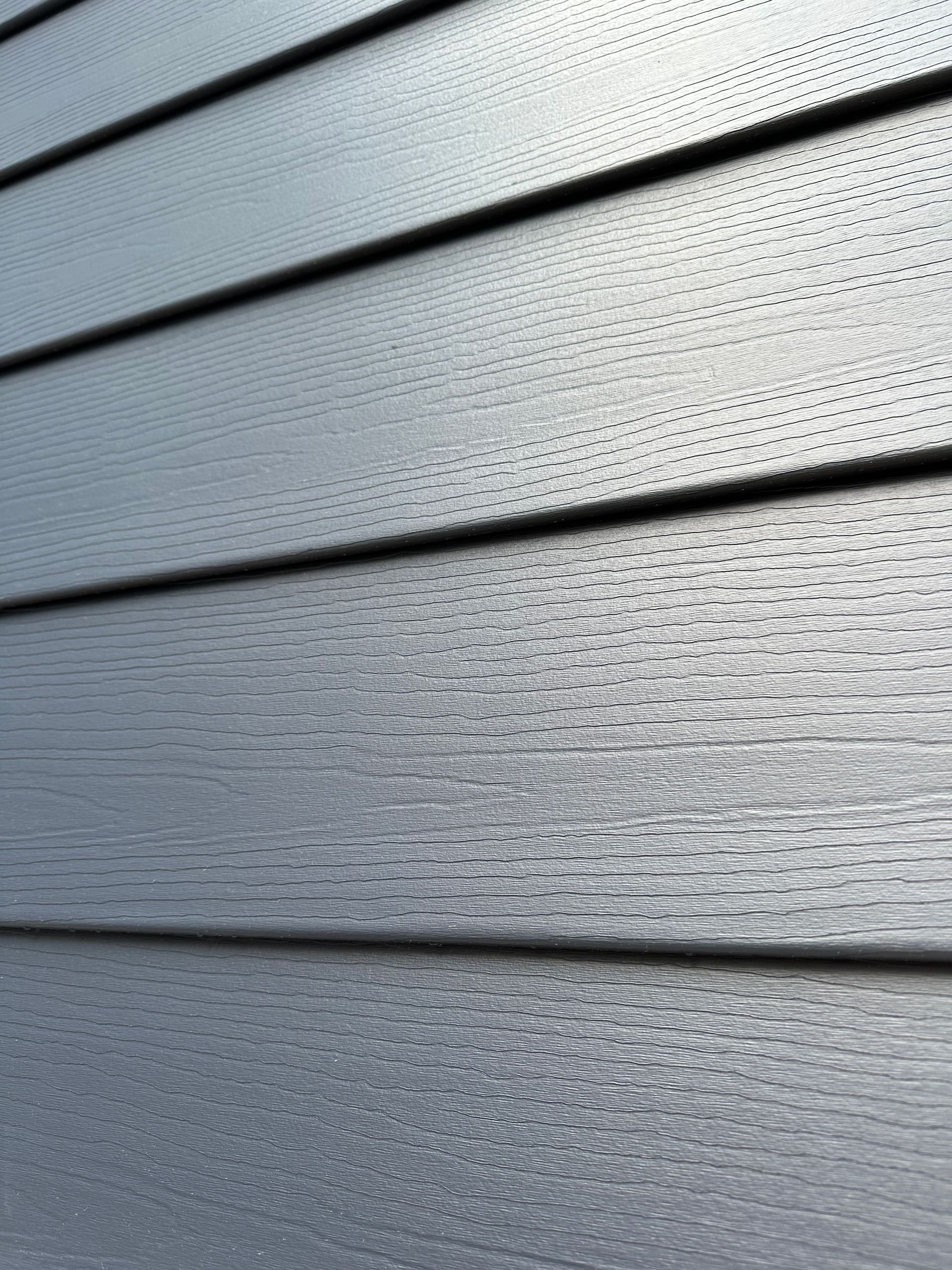 A close up of a gray siding on a house.