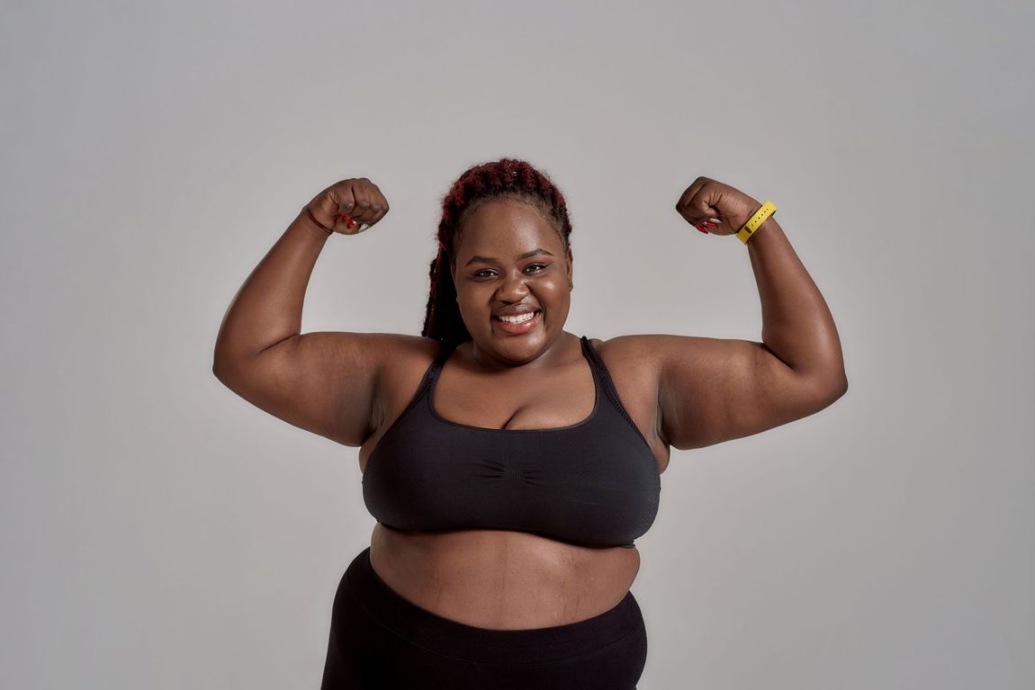 A woman in a sports bra is flexing her muscles.