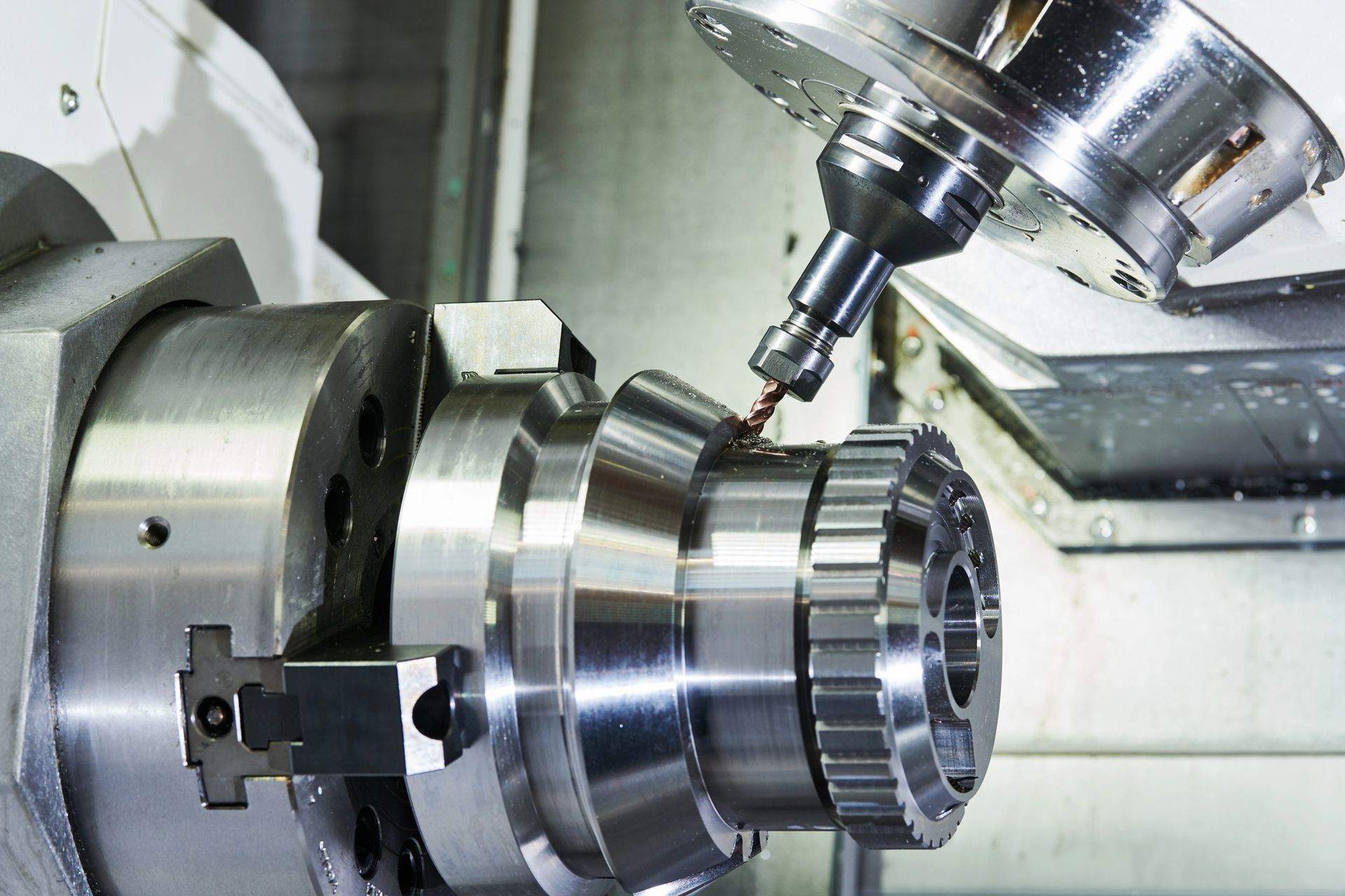 A machine is cutting a piece of metal on a lathe