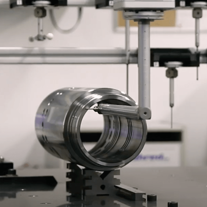 A metal object is being measured by a machine