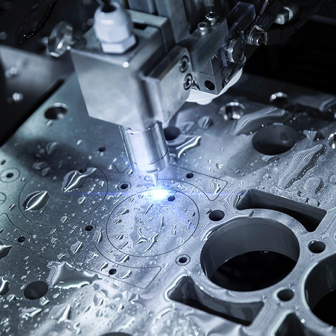 A machine is cutting a piece of metal with a laser.