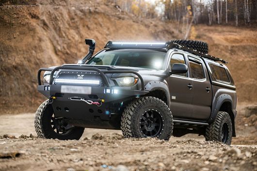 Large 4wd truck on a dirt hill that is completely modified with a snorkel and lights
