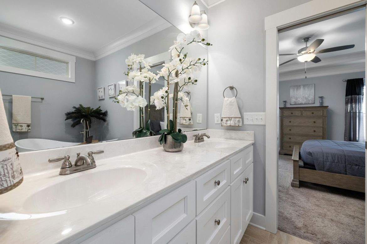 A bathroom with two sinks , a large mirror and a ceiling fan.