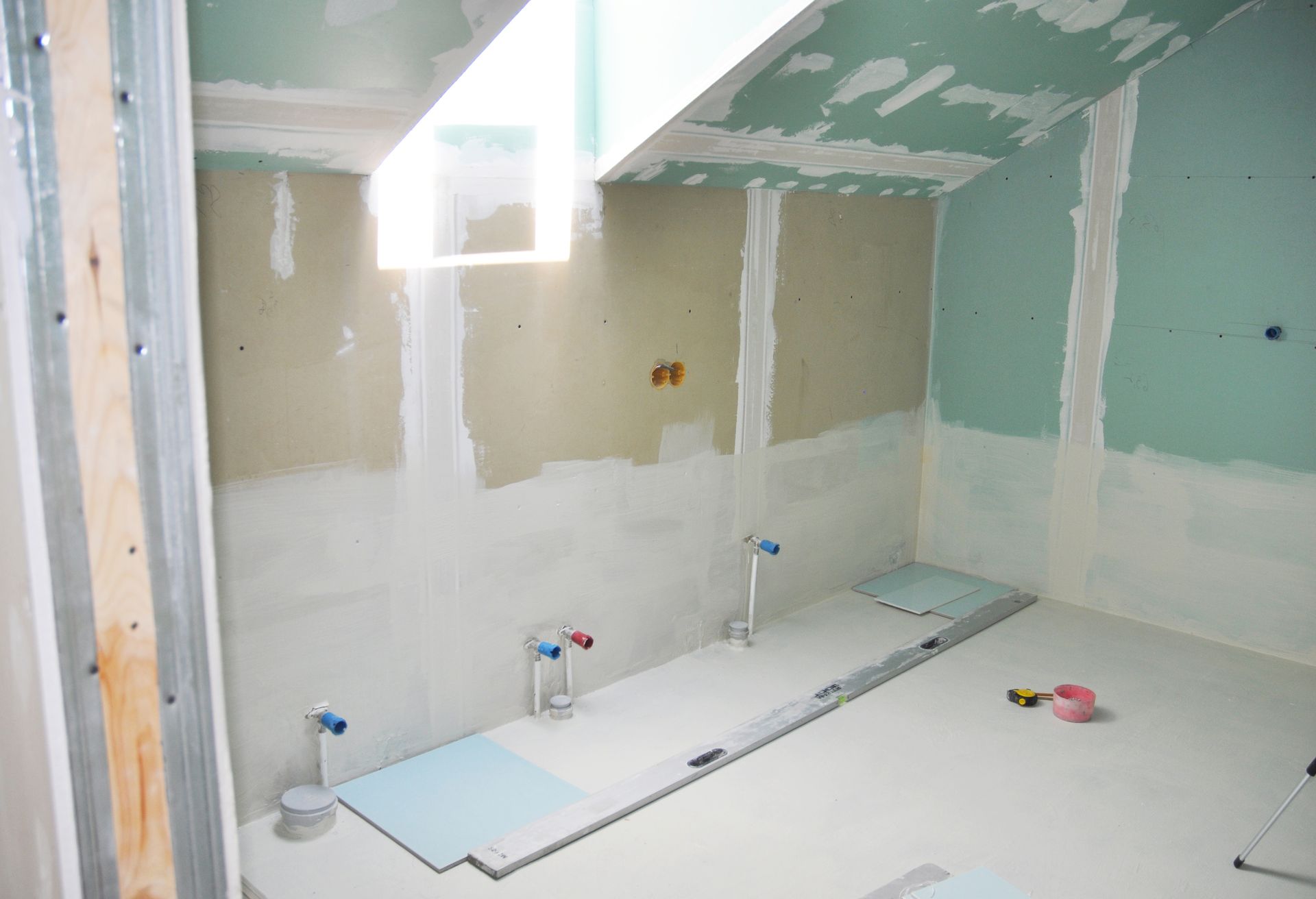 A bathroom under construction with a ceiling that is slanted.