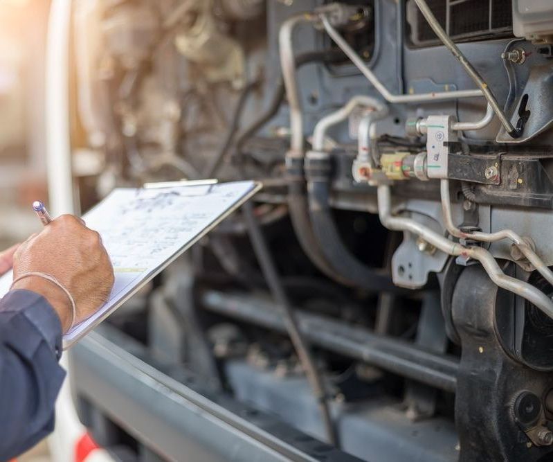 A Man is Writing on a Clipboard in Front of a Train Engine — Bob Parkes Automotive in Hyde Park, QLD