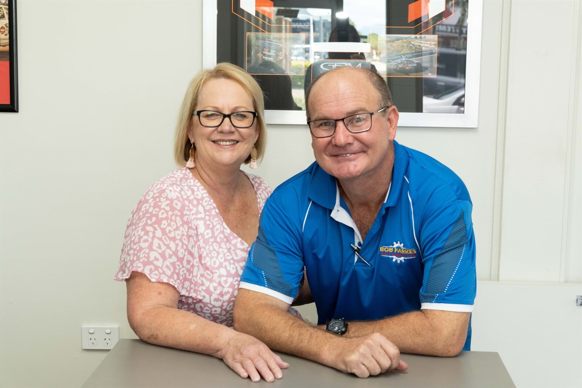 A Man and a Woman Are Posing for a Picture While Sitting at a Table — Bob Parkes Automotive in Hyde Park, QLD