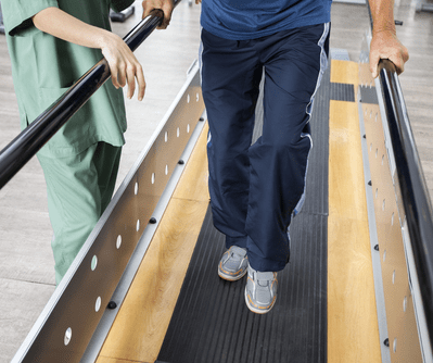Man Supports a Senior on Treadmill — Physiotherapists in Goulburn, NSW