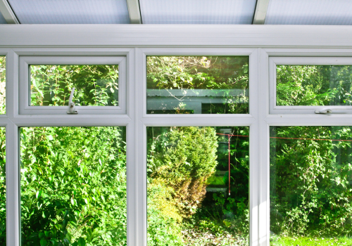 A conservatory with lots of windows and trees outside