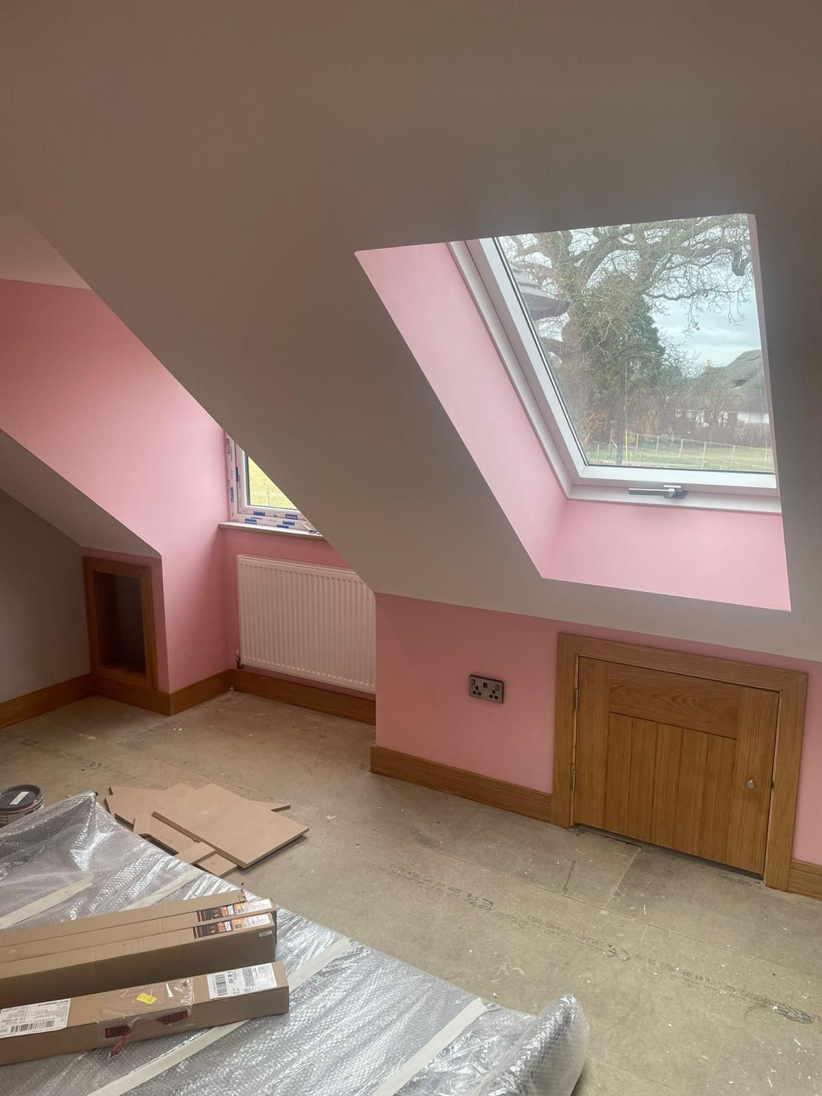 A room with pink walls and a skylight in the ceiling.