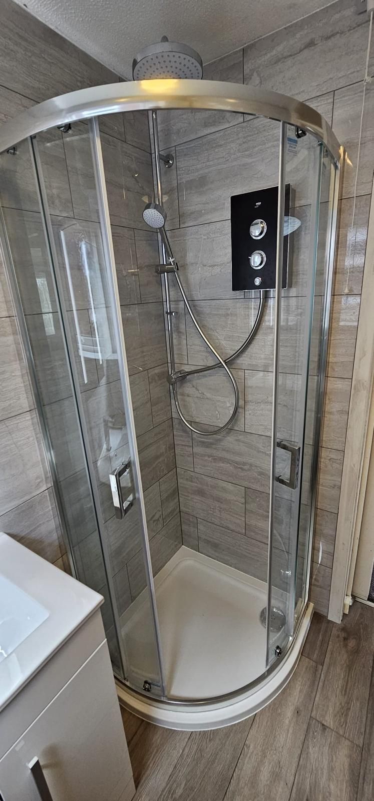 A bathroom with a shower stall and a sink.