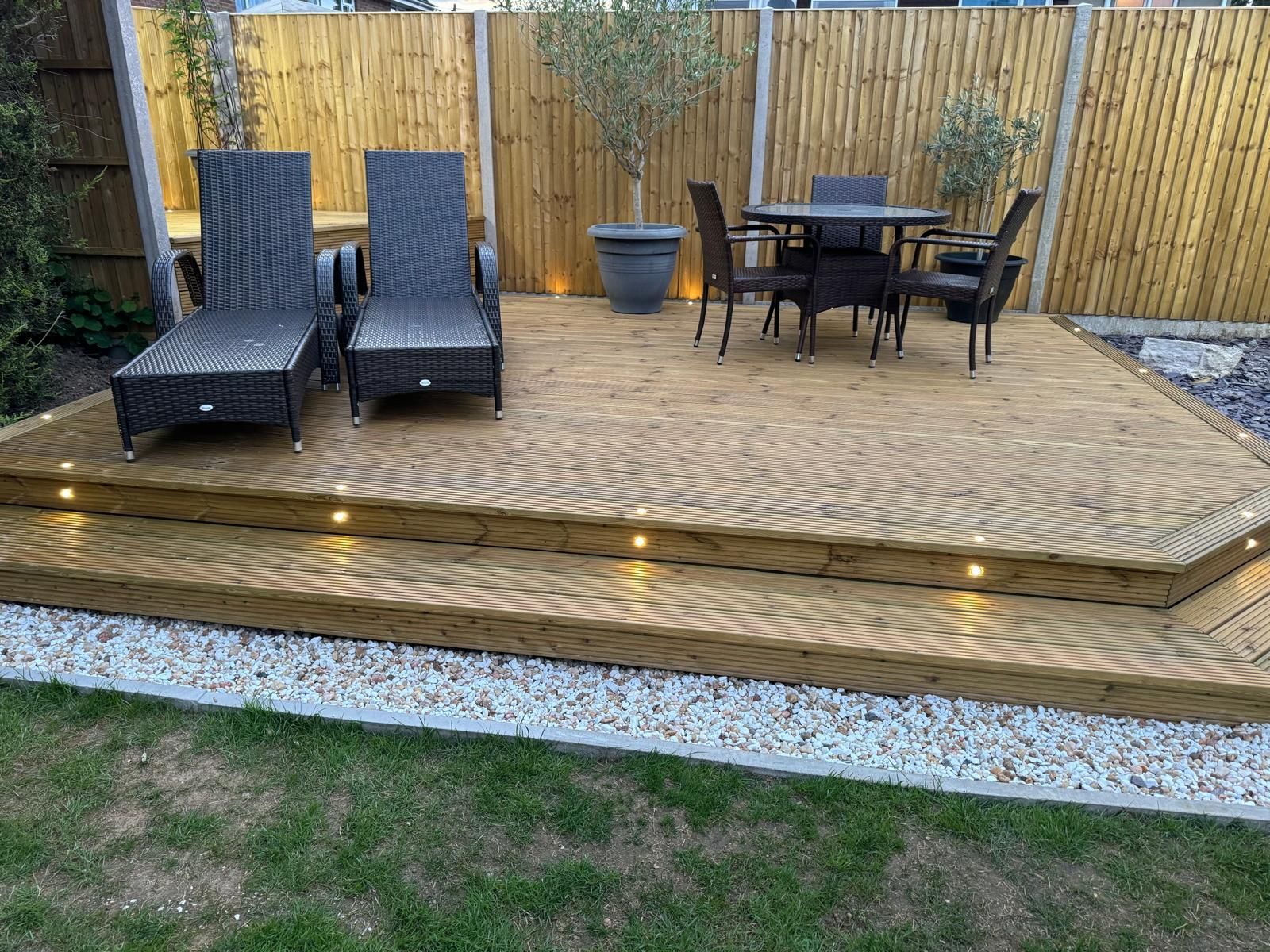 A wooden deck with a table and chairs on it.