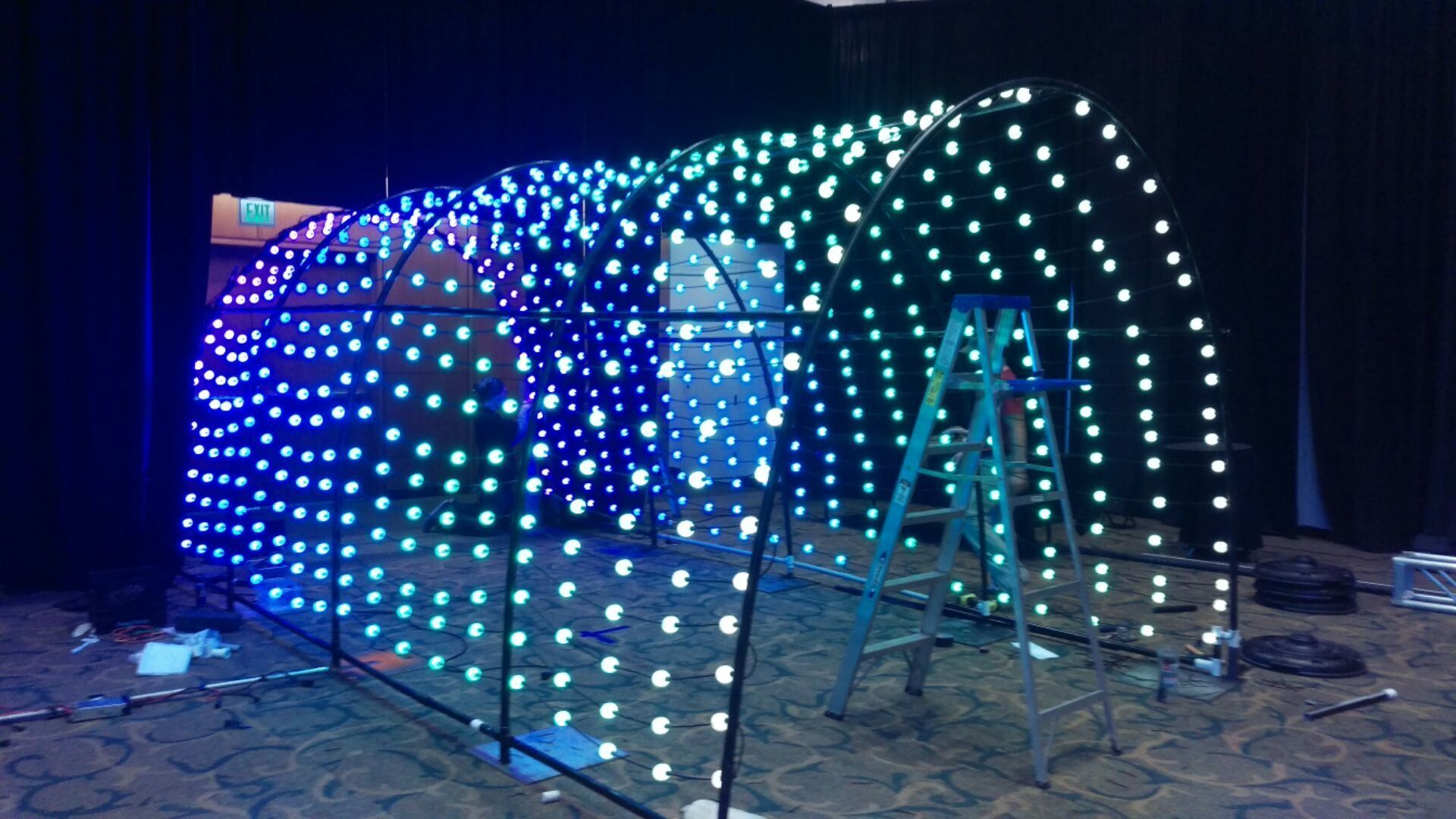 Colorful LED light tunnel structure glowing indoors on a dark floor