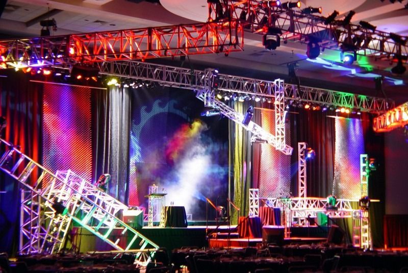Colorful concert stage with truss lighting, smoke, and bright LED screens
