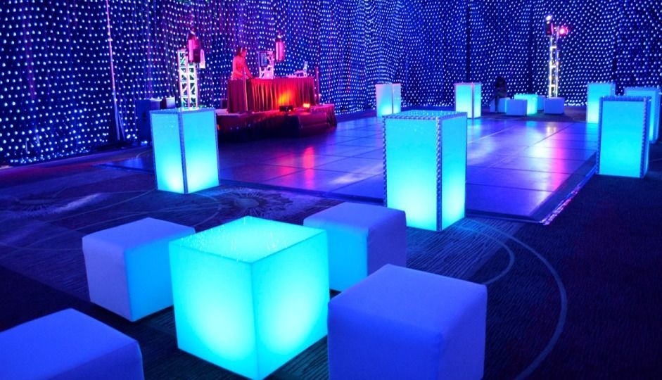 Glowing blue cube lights in a dark indoor venue with purple ambient lighting