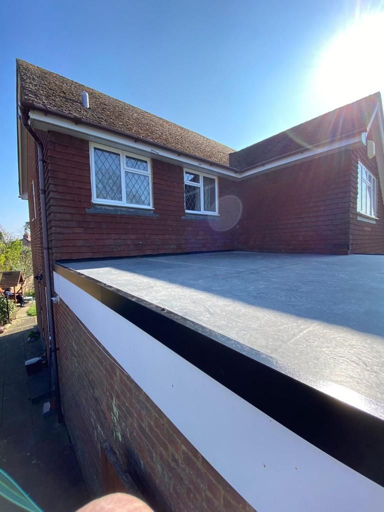 A house with a flat roof and a brick wall.