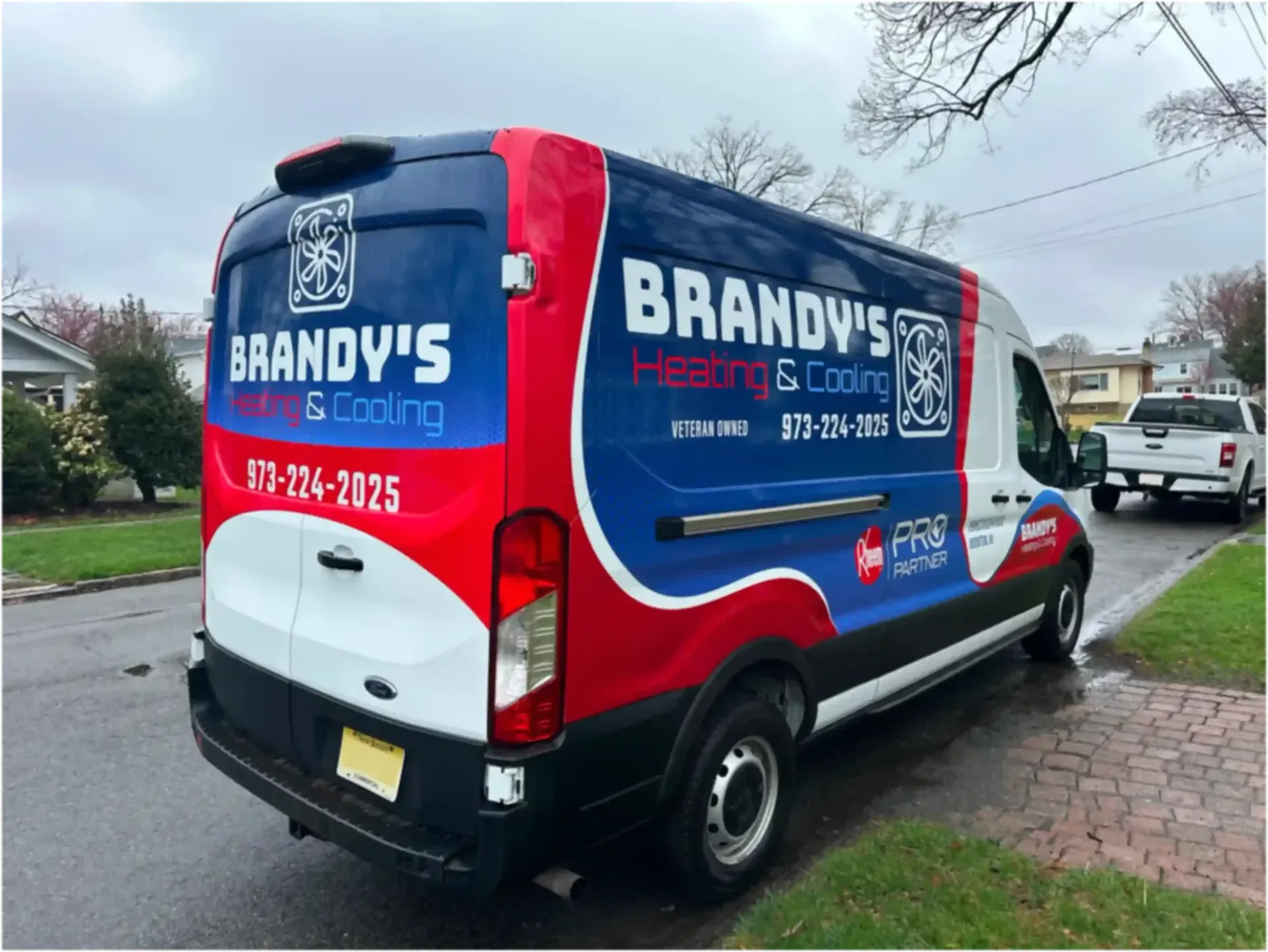Brandy's Heating & Cooling van parked on a brick-paved sidewalk with red, white, and blue company graphics.