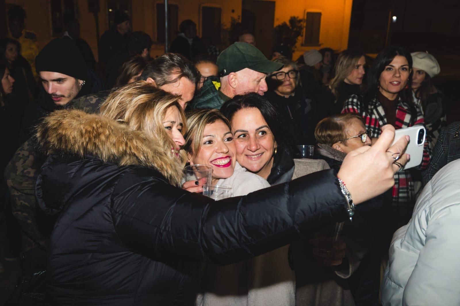 Un gruppo di persone si scatta un selfie con un cellulare.