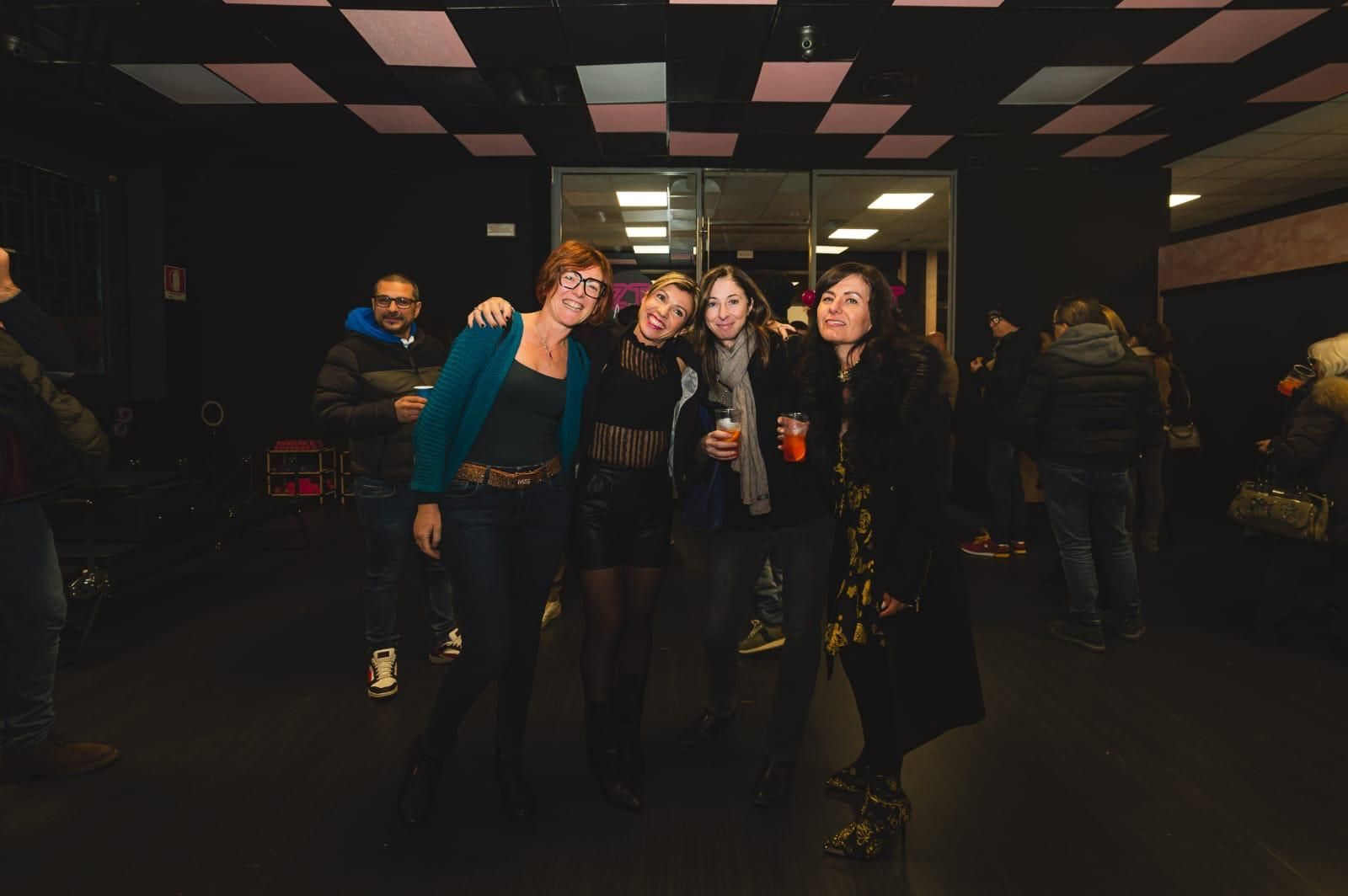 Un gruppo di persone posa per una foto in una stanza buia.