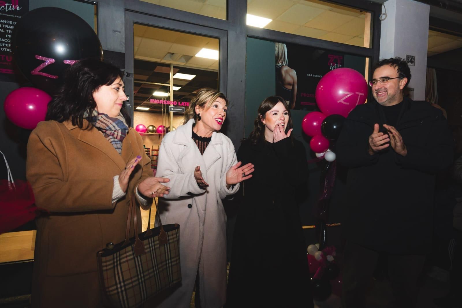 Un gruppo di persone è in piedi davanti a un negozio con dei palloncini.