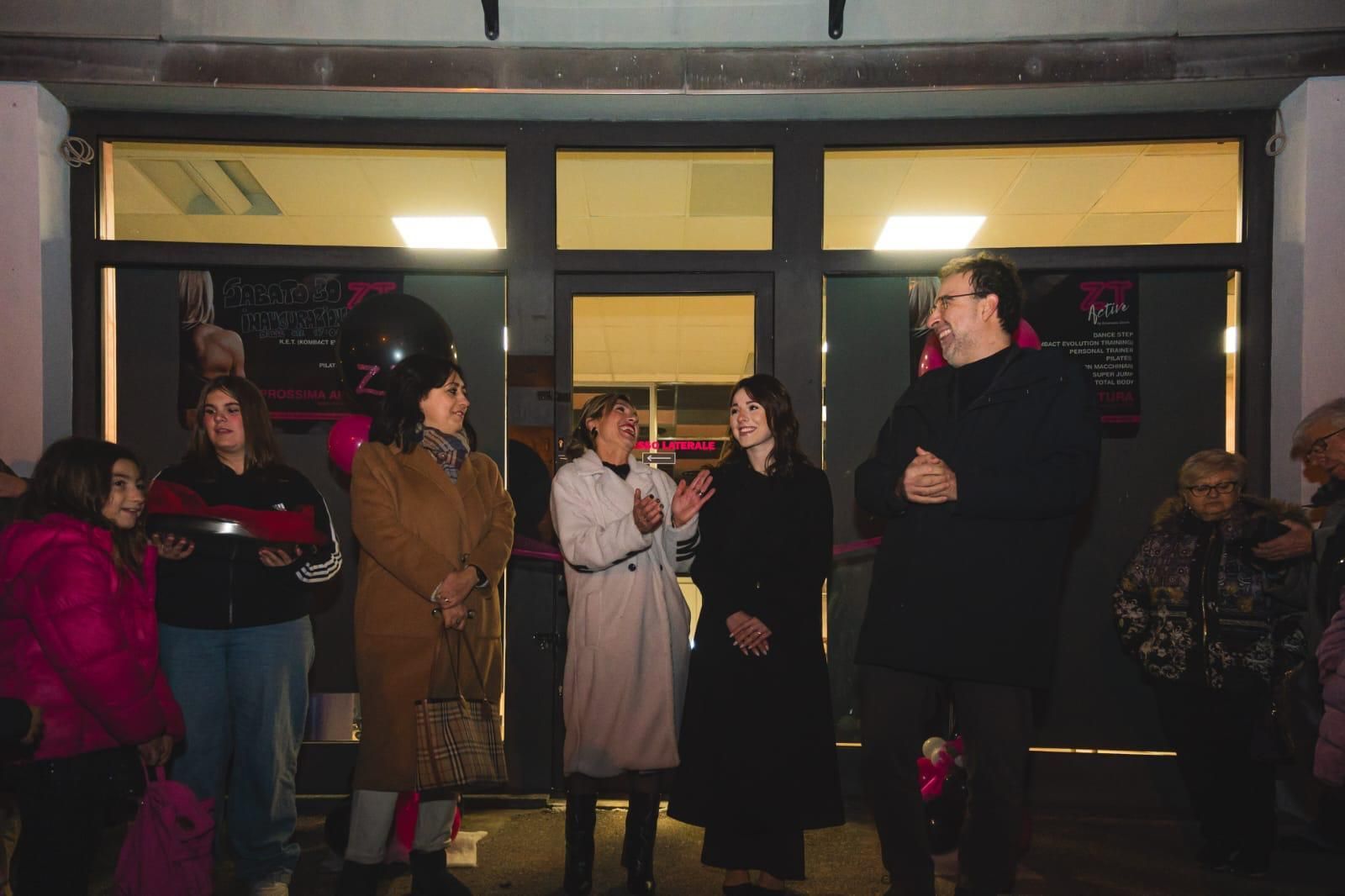 Un gruppo di persone è in piedi davanti a un edificio.