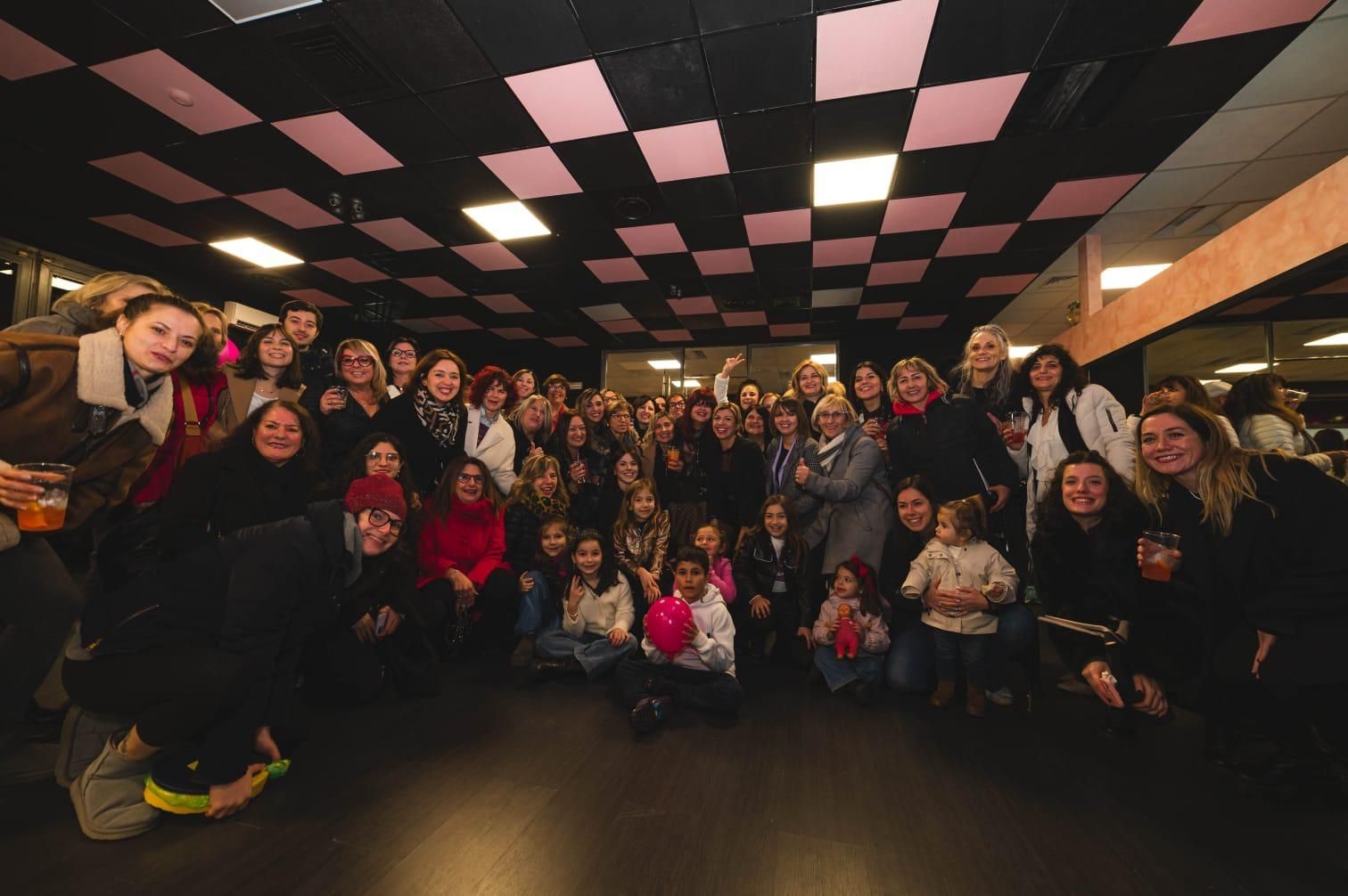 Un folto gruppo di persone posa per una foto in una stanza.