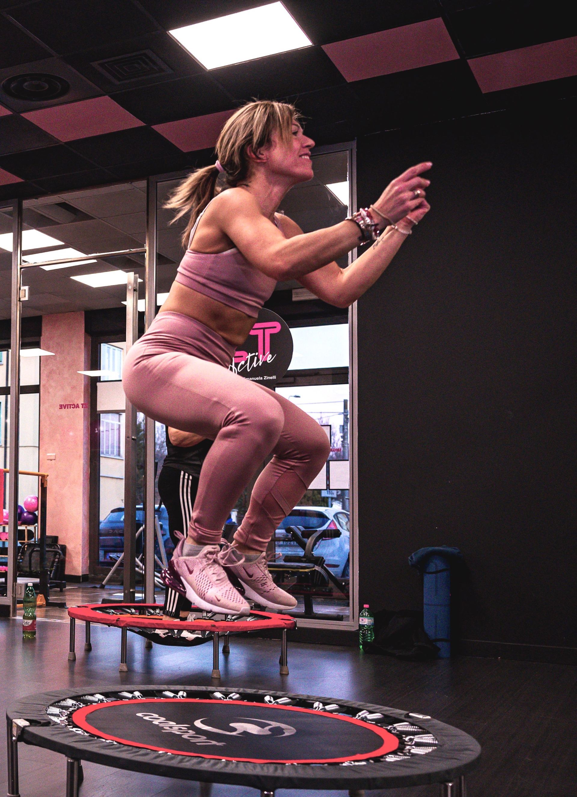 Una donna salta su un trampolino in una palestra.