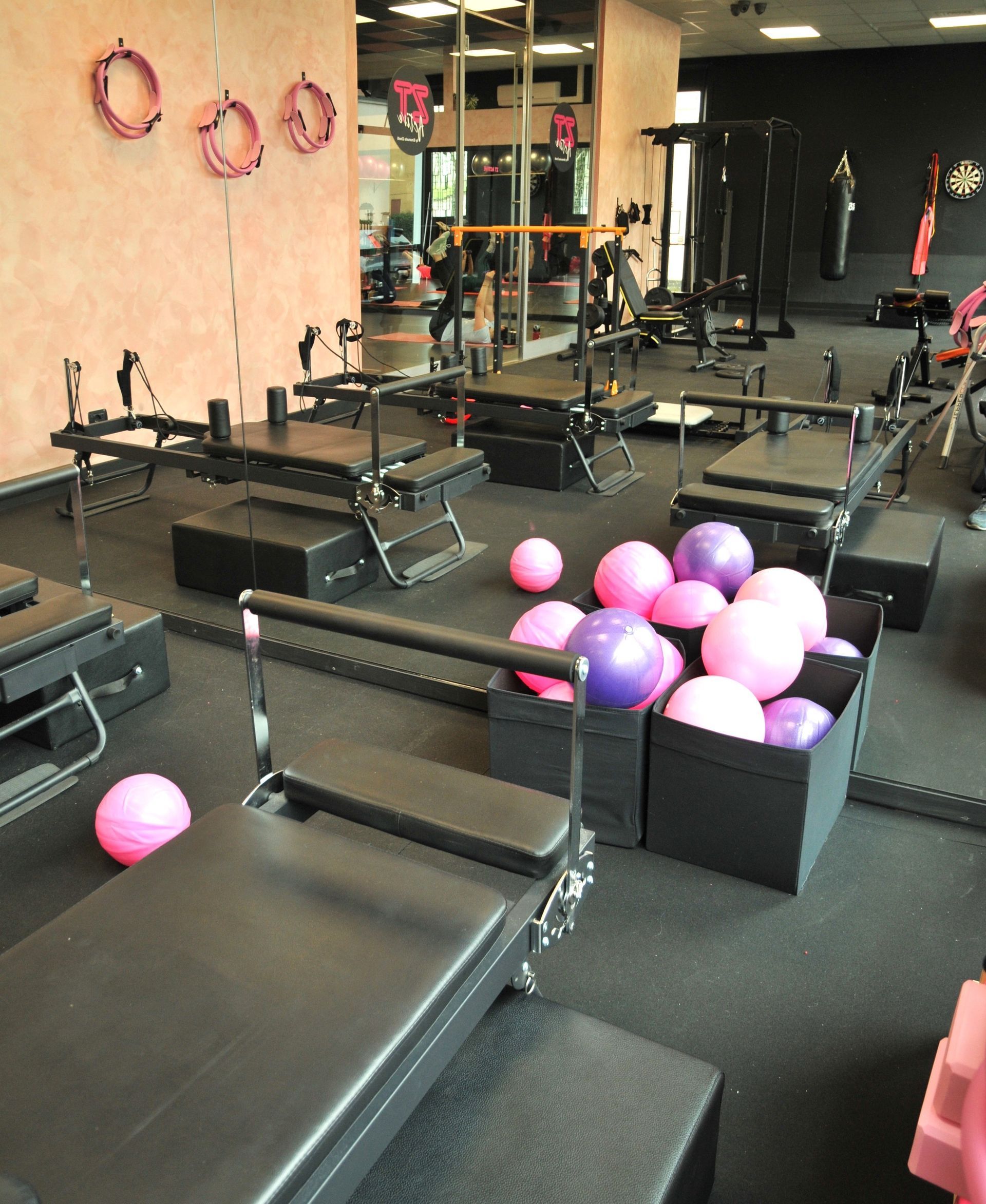 Una palestra piena di palline rosa e viola e attrezzi per l'esercizio fisico