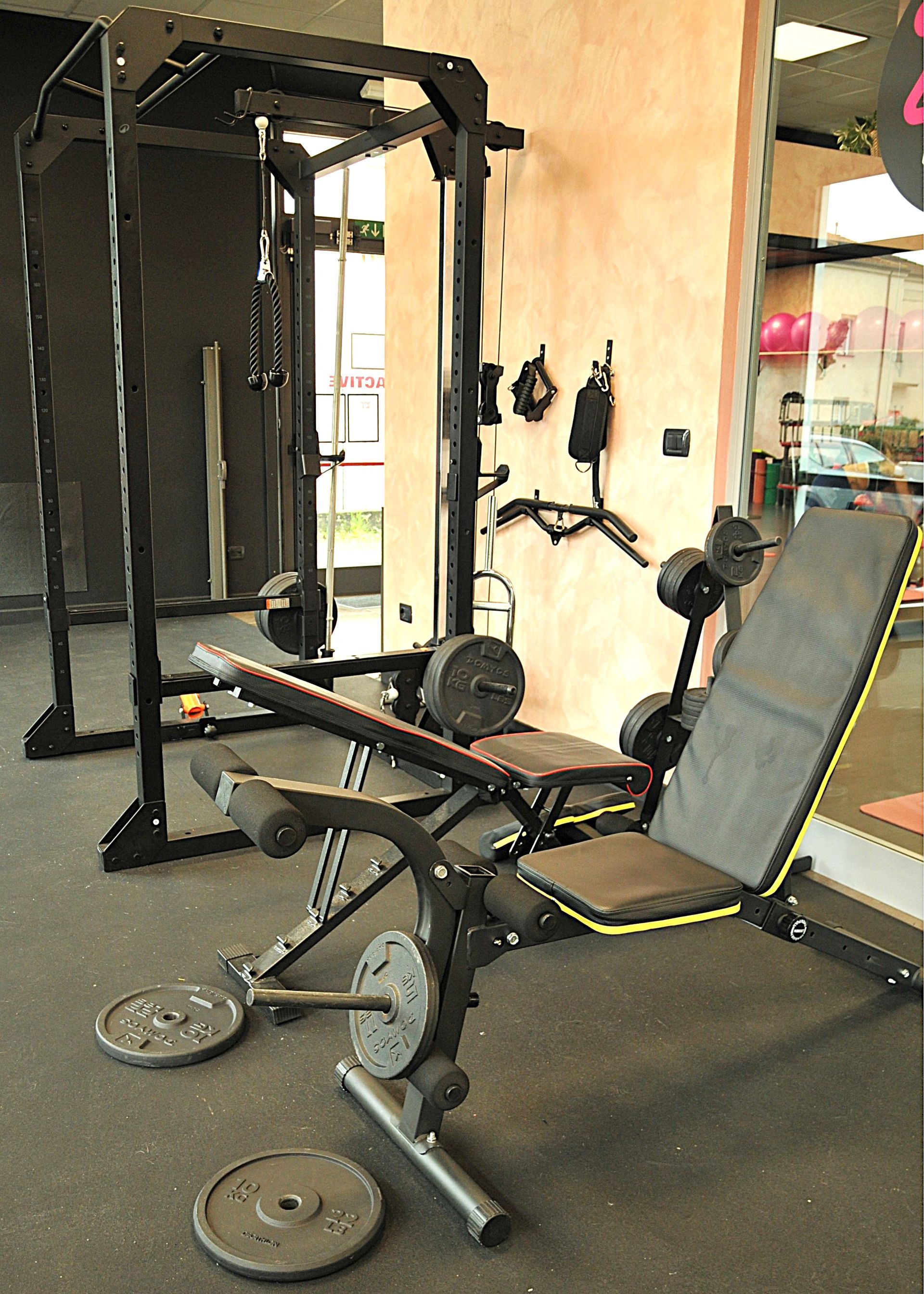 Una palestra con una panca e manubri sul pavimento.