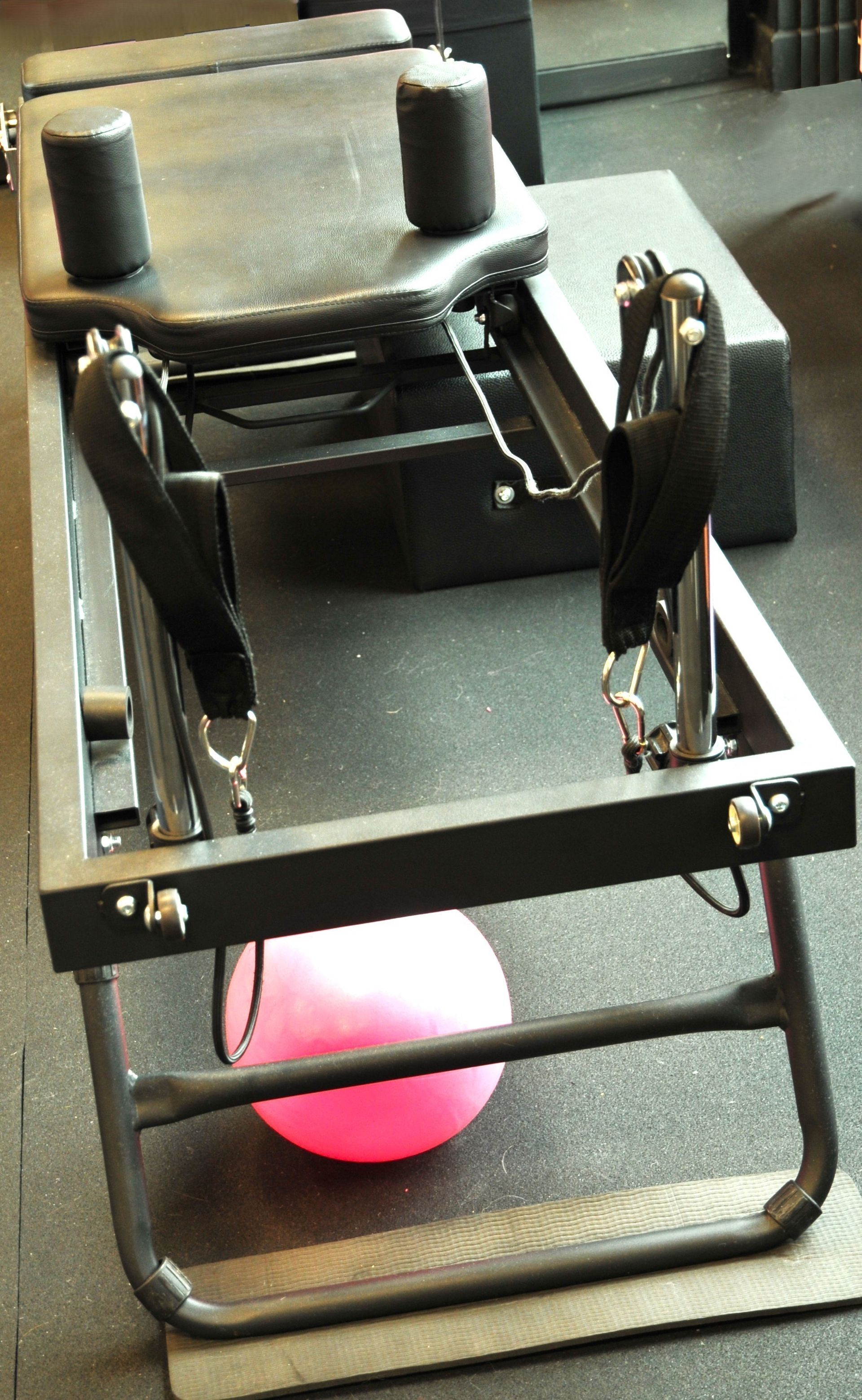 Una palla rosa è appoggiata su una macchina per pilates