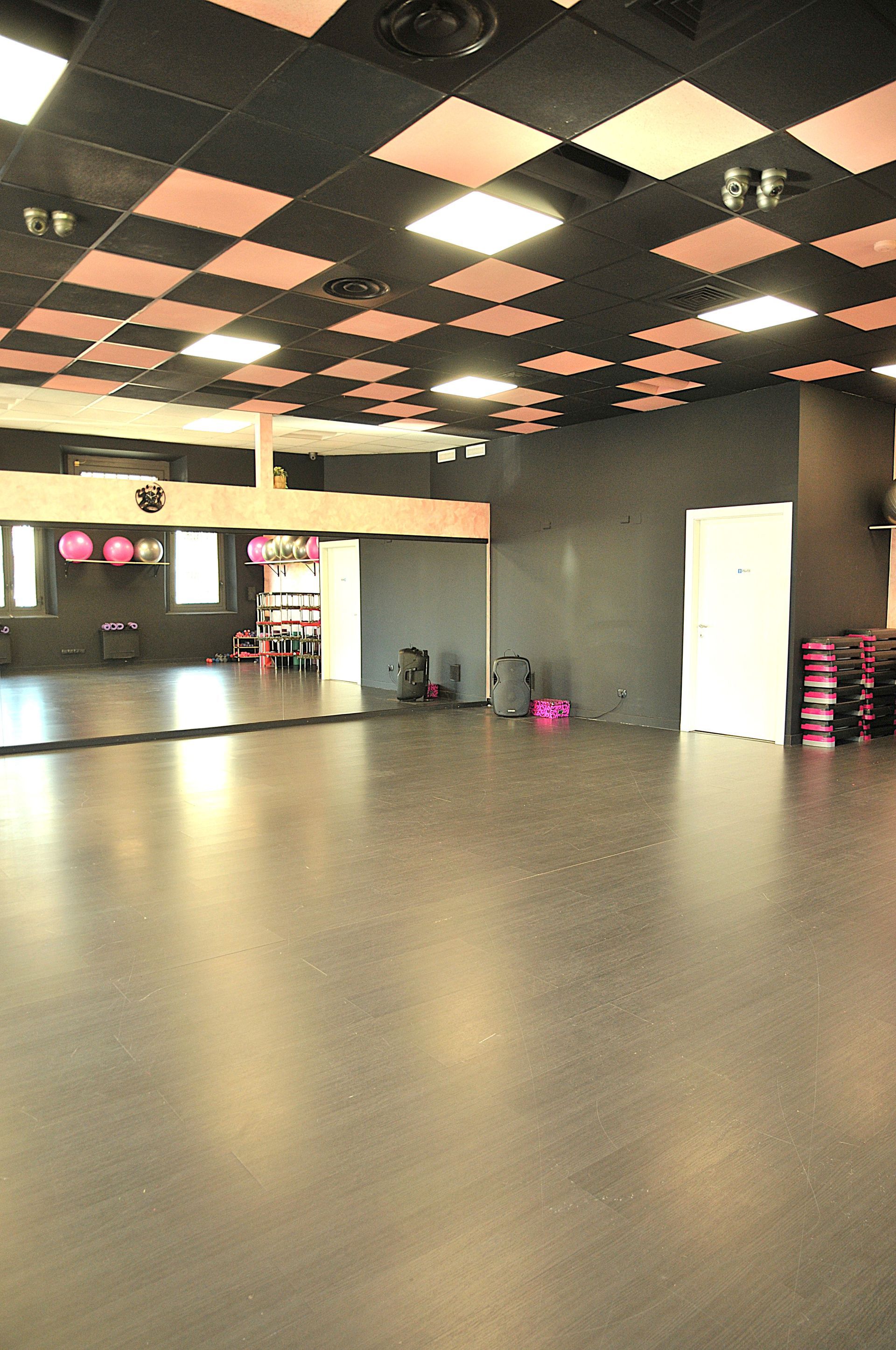 Uno studio di danza vuoto con un grande specchio sul muro.