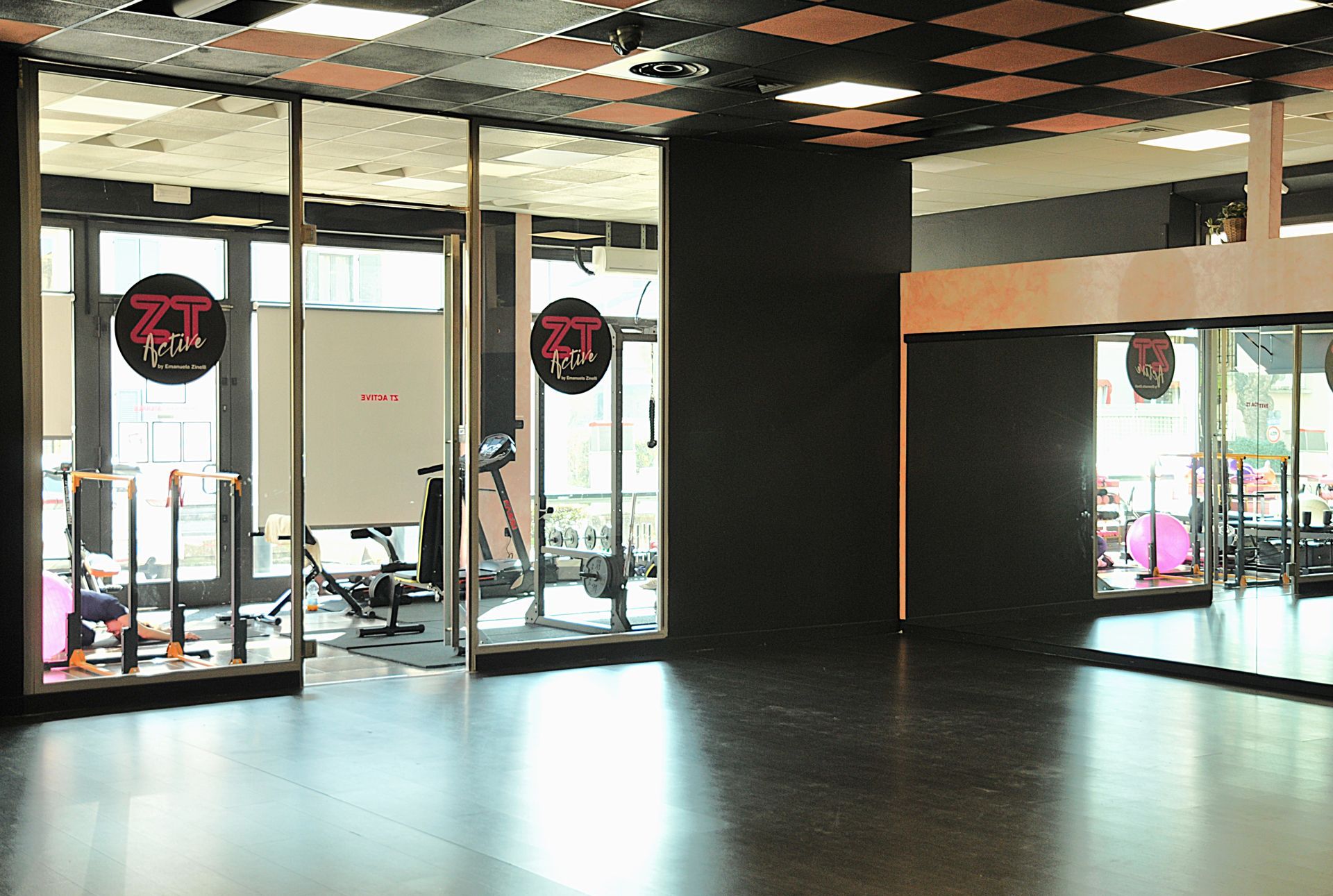 Una grande palestra vuota con un sacco di palle da ginnastica sul muro.