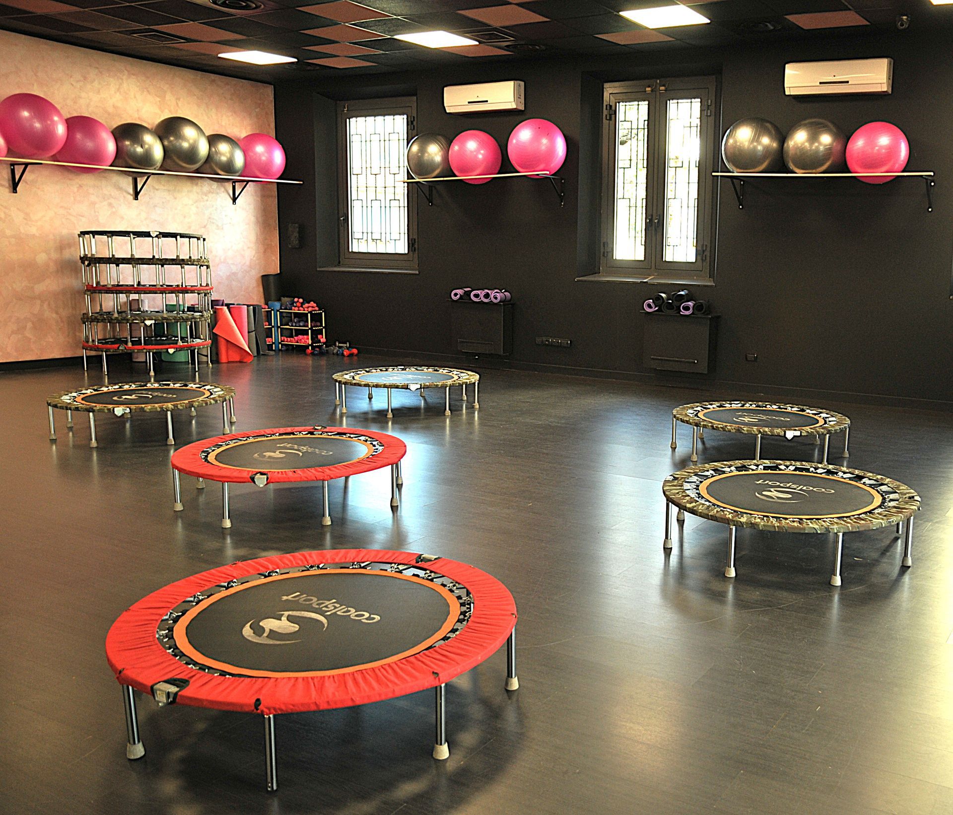 Una stanza piena di trampolini e palle da pilates