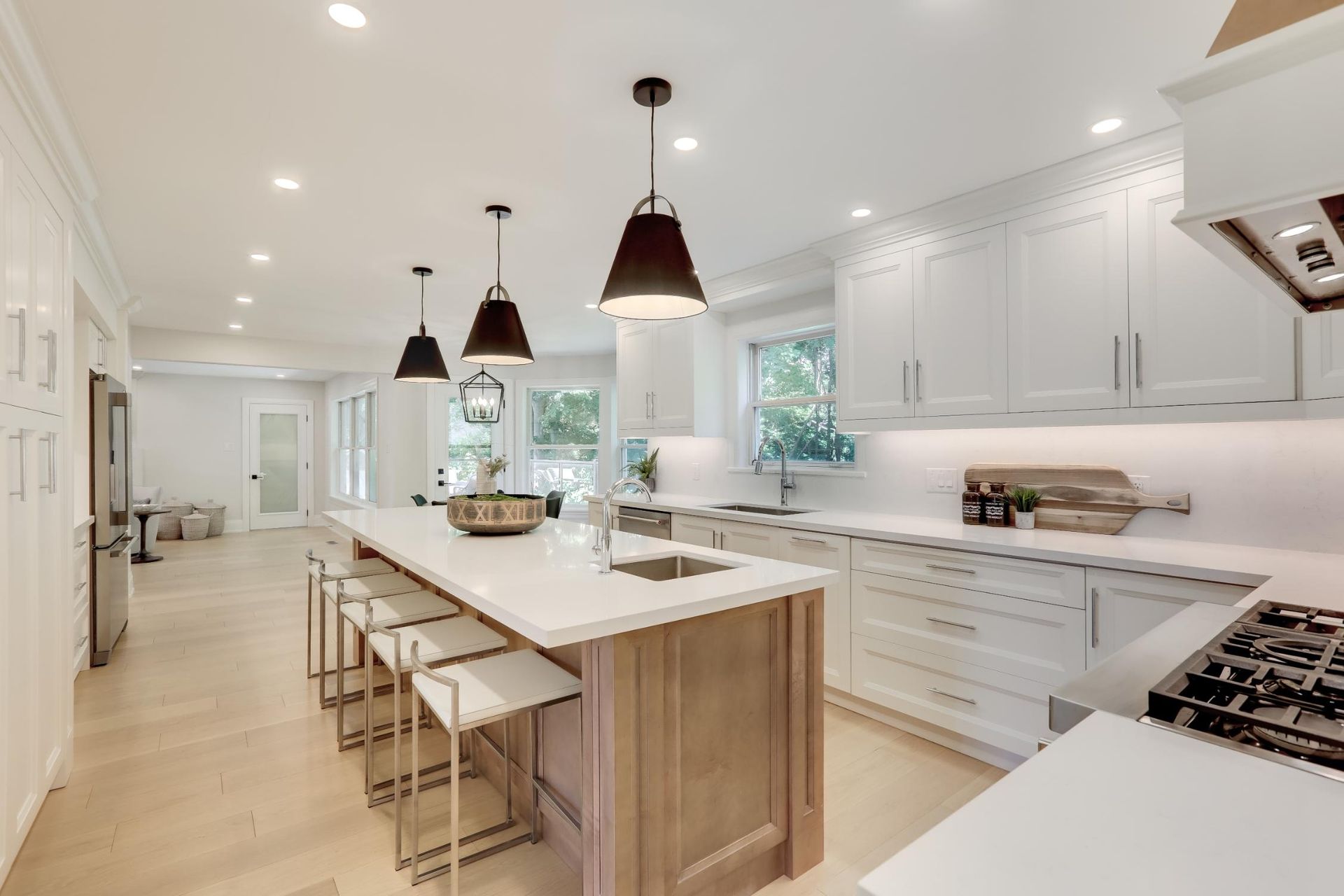 A kitchen with white cabinets and a large island in the middle.